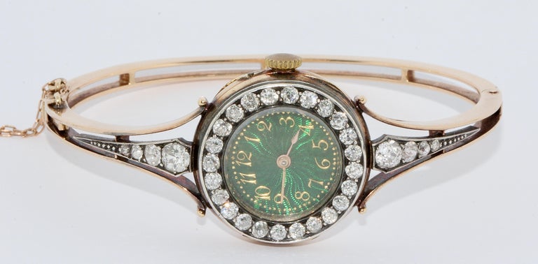 Magnificent, antique gold ladies' wristwatch with diamonds and enamel dial.


The watch is set with a total of 32 old cut diamonds.
The beautiful, green enamel dial with golden Arabic numerals is striking.

Bangle and Case made of solid