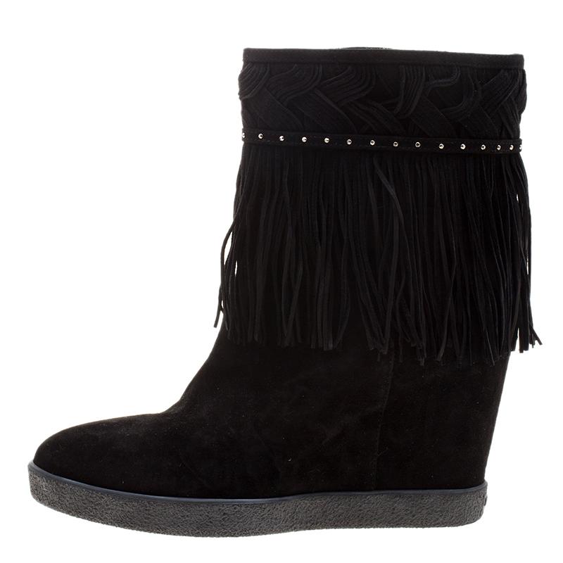 Add a fun and flirty look to your winter wardrobe with these beautiful Le Silla wedge boots. Constructed in black suede, these boots are made interesting with a studded belt around the ankle and the fringed details covering all around the belt. With