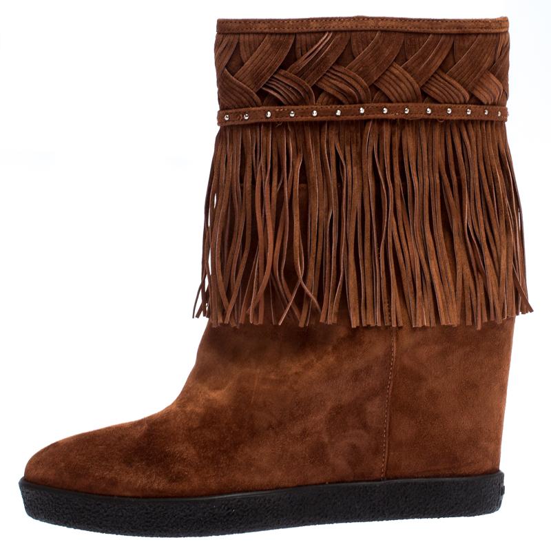 Crafted from brown suede, these gorgeous boots are designed by Le Silla. This luxurious pair of footwear comes with fringed accents at the ankles along with 9.5 cm concealed wedge heels. The stylish pair makes a perfect addition to your