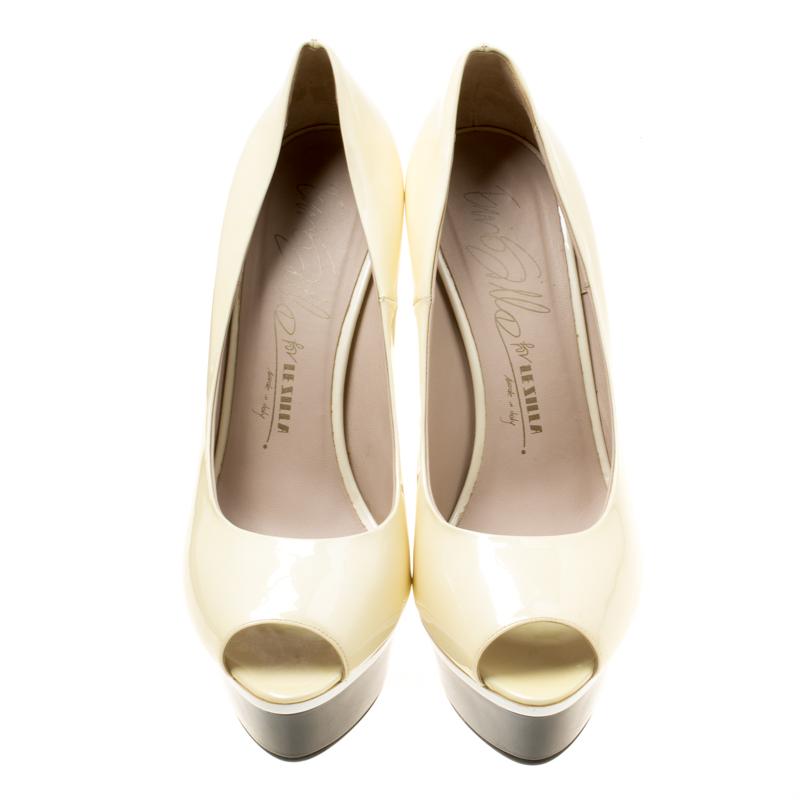 You're all set to touch the skies in these gorgeous pumps from Le Silla! The cream pumps are crafted from patent leather and feature a peep-toe silhouette. They come equipped with comfortable leather lined insoles, 15.5 cm heels and solid platforms