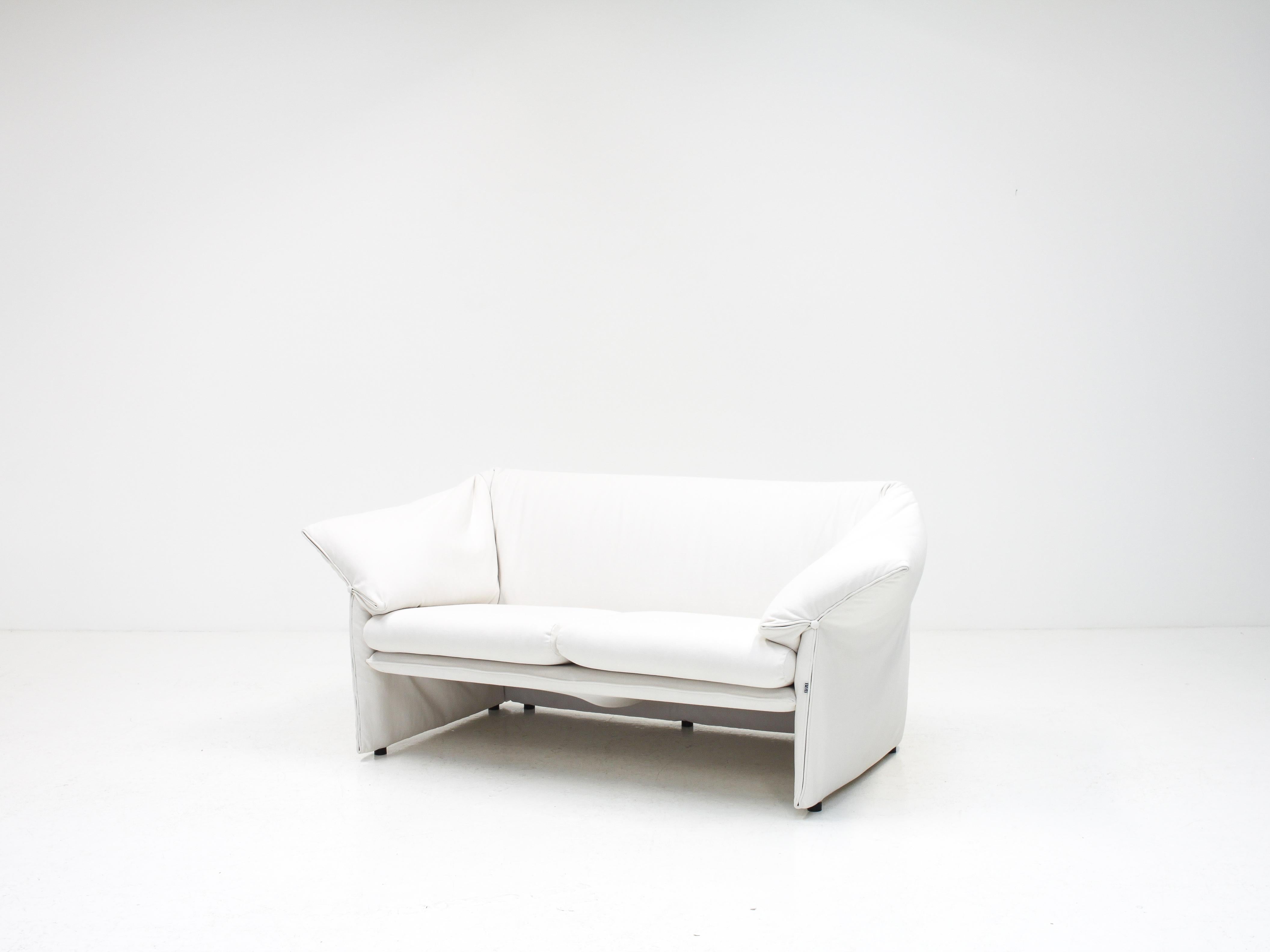A beautiful example of a two-seat 'Le Stelle' loveseat sofa by Mario Bellini for B&B Italia, designed in 1974. Reupholstered in fresh, white linen.

The piece retains its original labels and is also signed with a B&B tag on the front seam.

An early