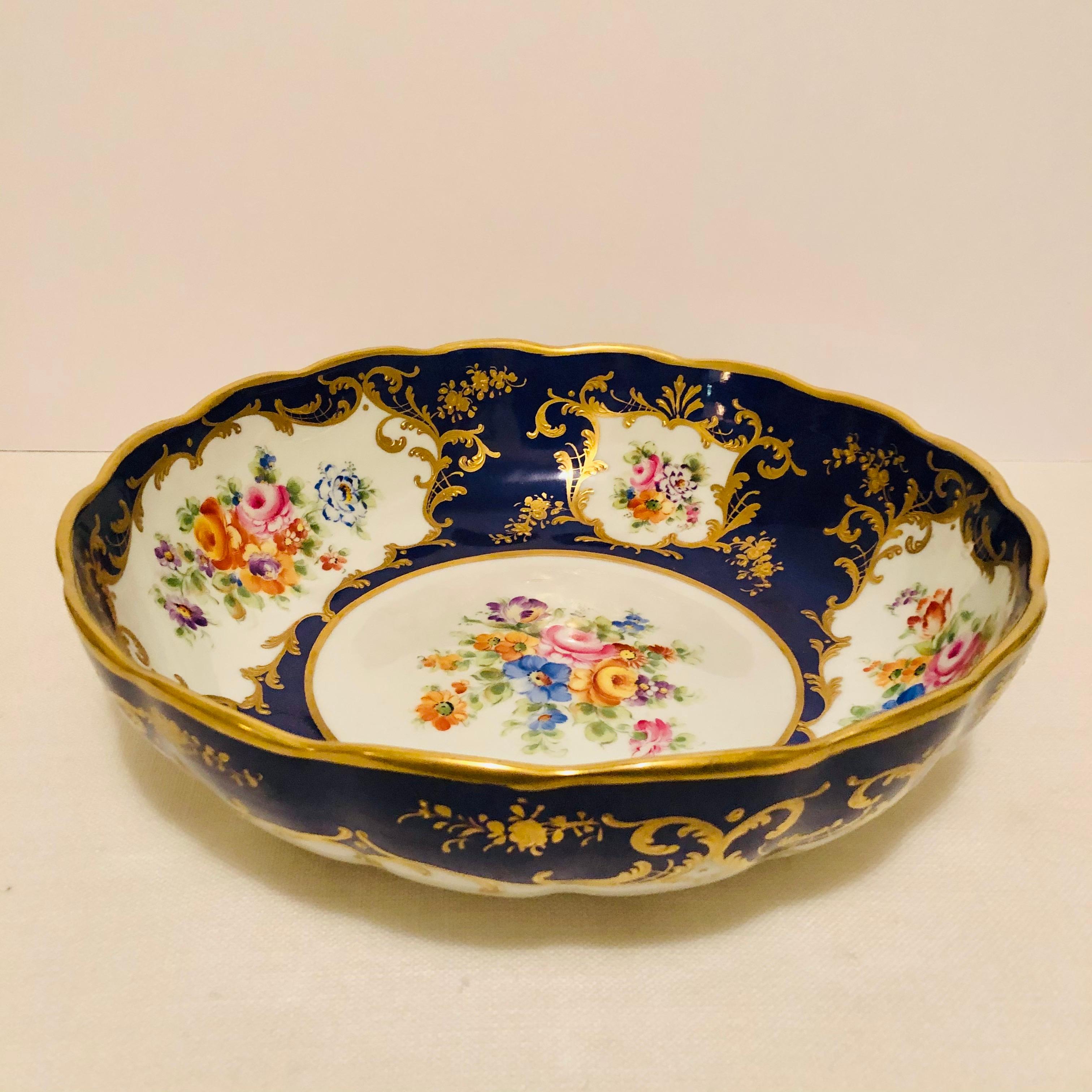 This is a gorgeous royal blue Le Tallec bowl with a hand-painted central flower bouquet and four painted colorful bouquet cartouches on the inside of the bowl. The bowl is accented with raised gold arabesque decoration as well as raised gilded
