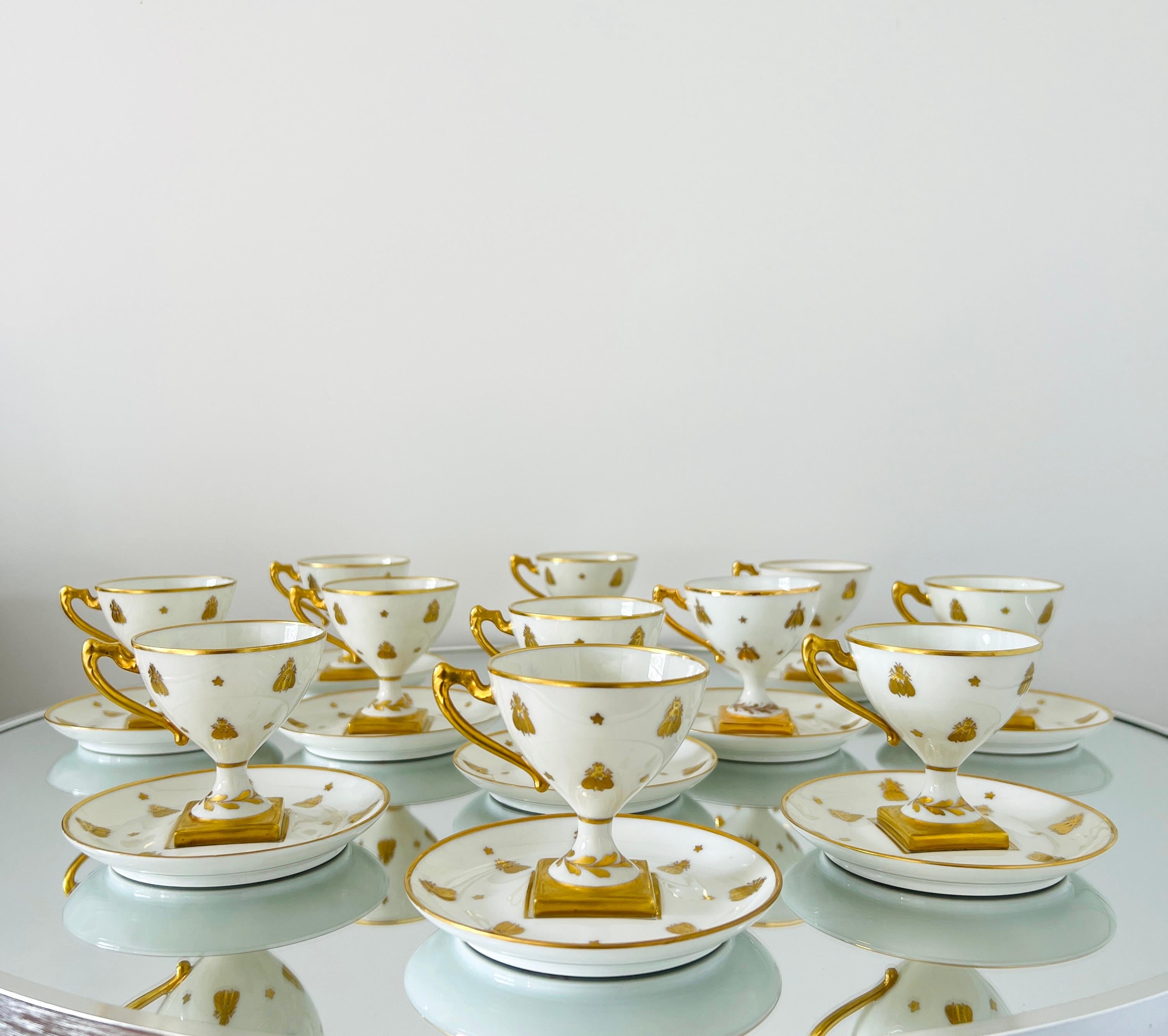 Exquisito juego de demitas neoclásico de porcelana fina y oro de 24 quilates de Camille Le Tallec. El motivo pertenece a la Colección Abeilles, con abejas doradas napoleónicas pintadas a mano en oro sobre porcelana blanca. El juego incluye 11 tazas