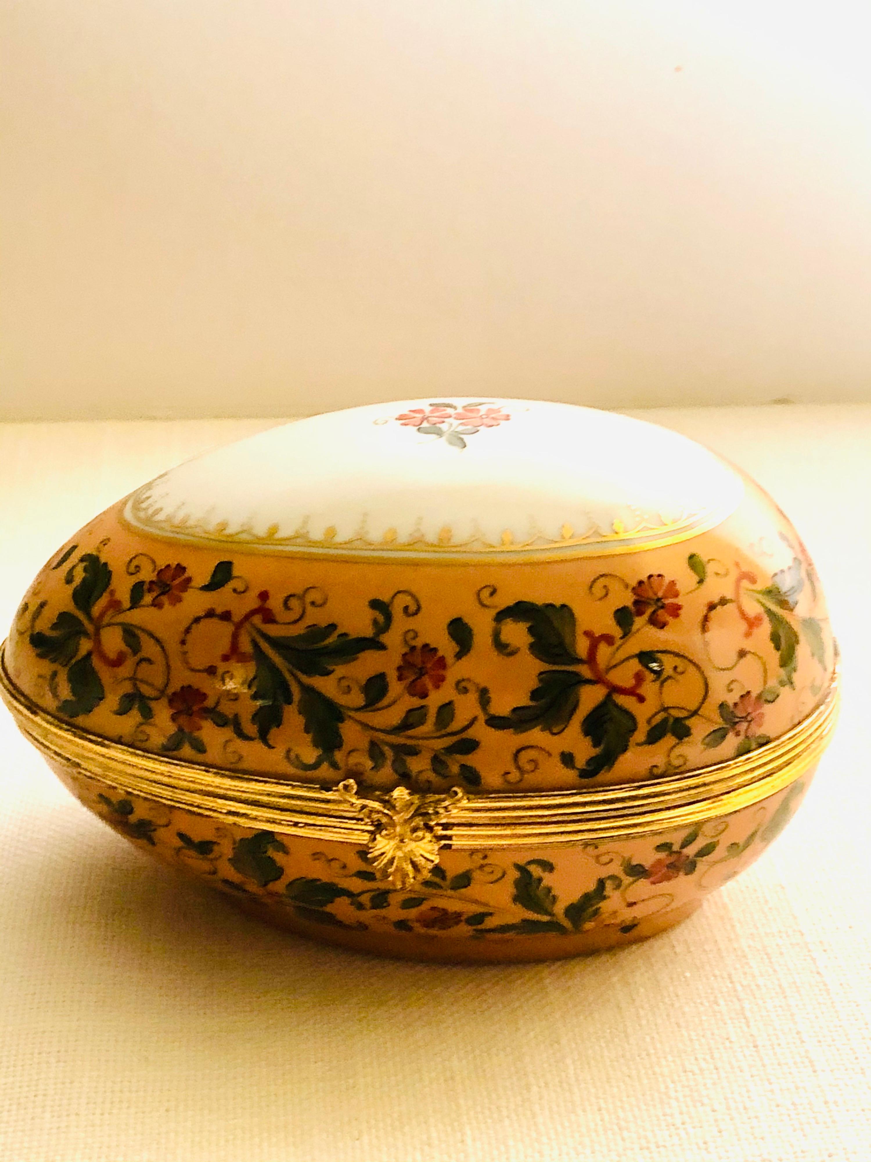 I want to offer you this beautifully painted Le Tallec egg shaped box which is decorated with hand-painted peach flowers and green leaves. This was decorated in the famous studio of Le Tallec, which was later bought by Tiffany and Company. This