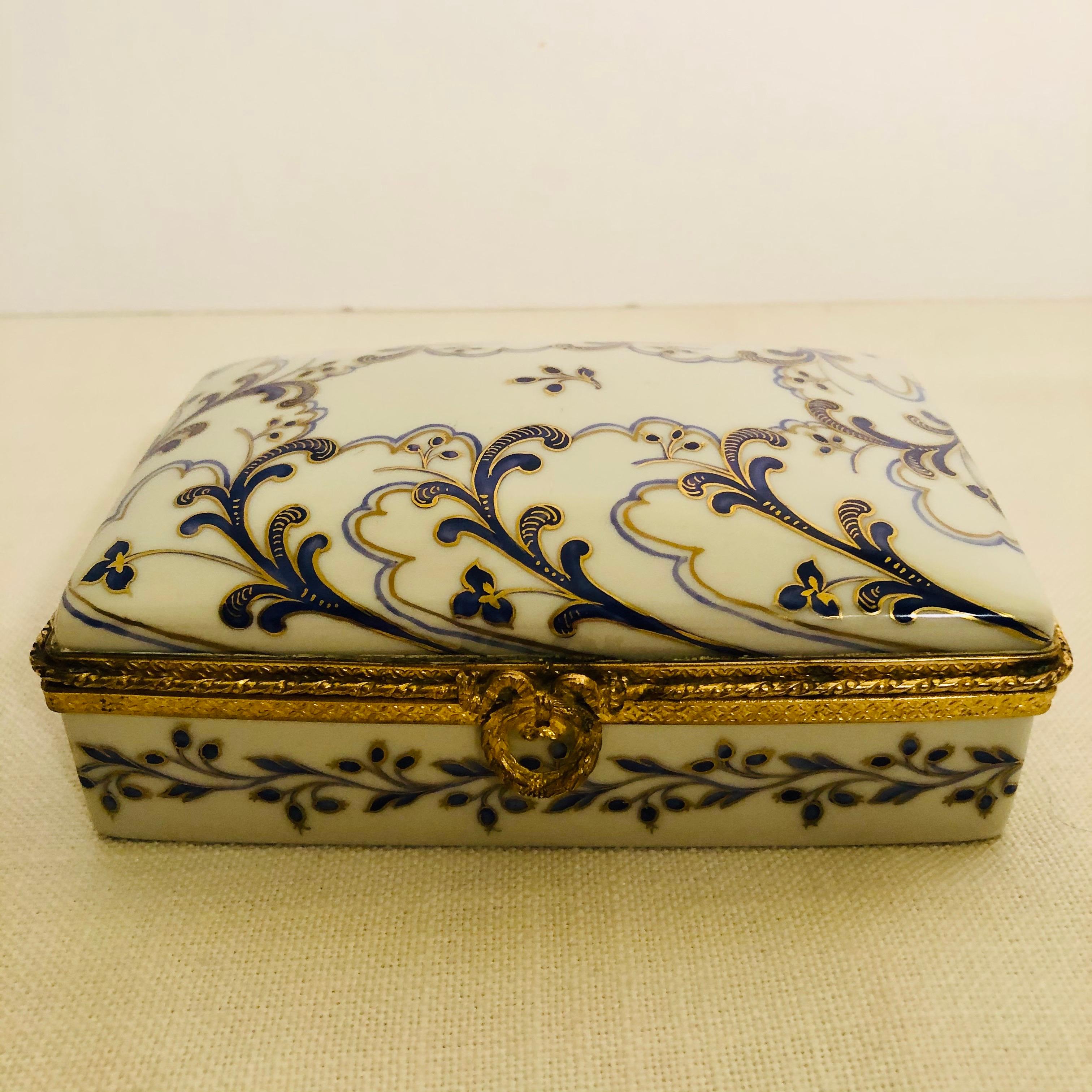 Je souhaite vous offrir cette belle boîte en porcelaine Le Tallec qui est peinte à la main avec un décor d'arabesques cobalt et or sur un fond blanc. Cette boîte Le Tallec serait un ajout spécial pour tous ceux qui collectionnent les boîtes en