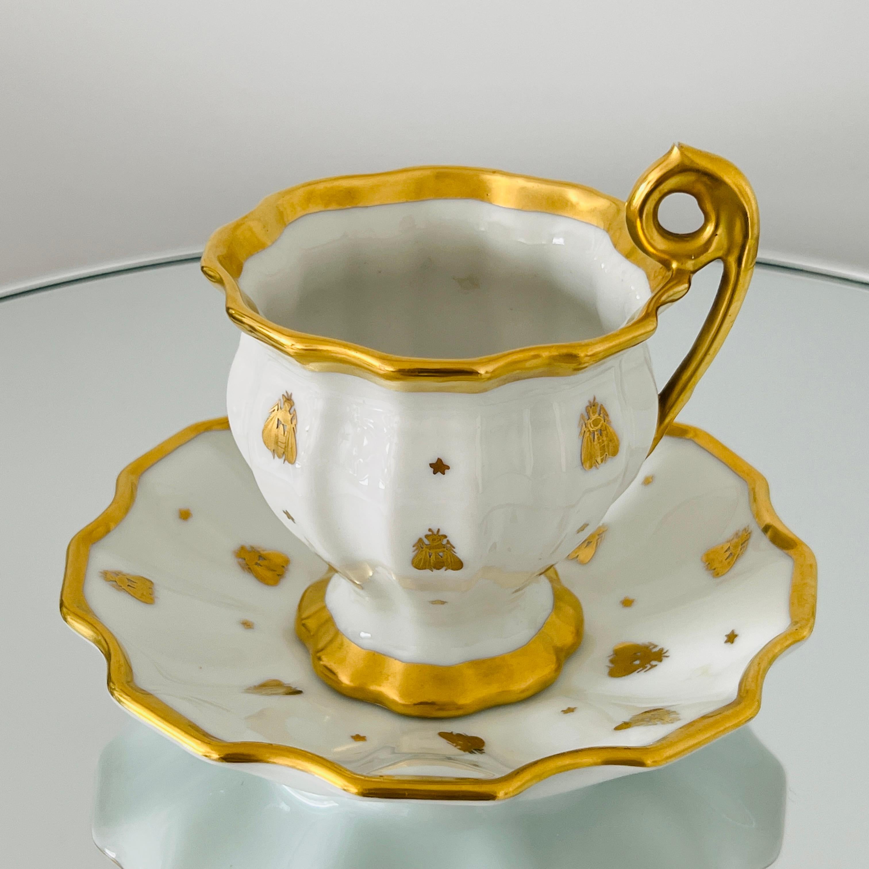 1950s Le Tallec porcelain candy cup with dish set from the Abeilles (Golden Bees) Collection. The Empire pattern features Napoleonic golden bee motif hand painted in 24K gold over fine white porcelain. The cup has a tapered form with fluted sides