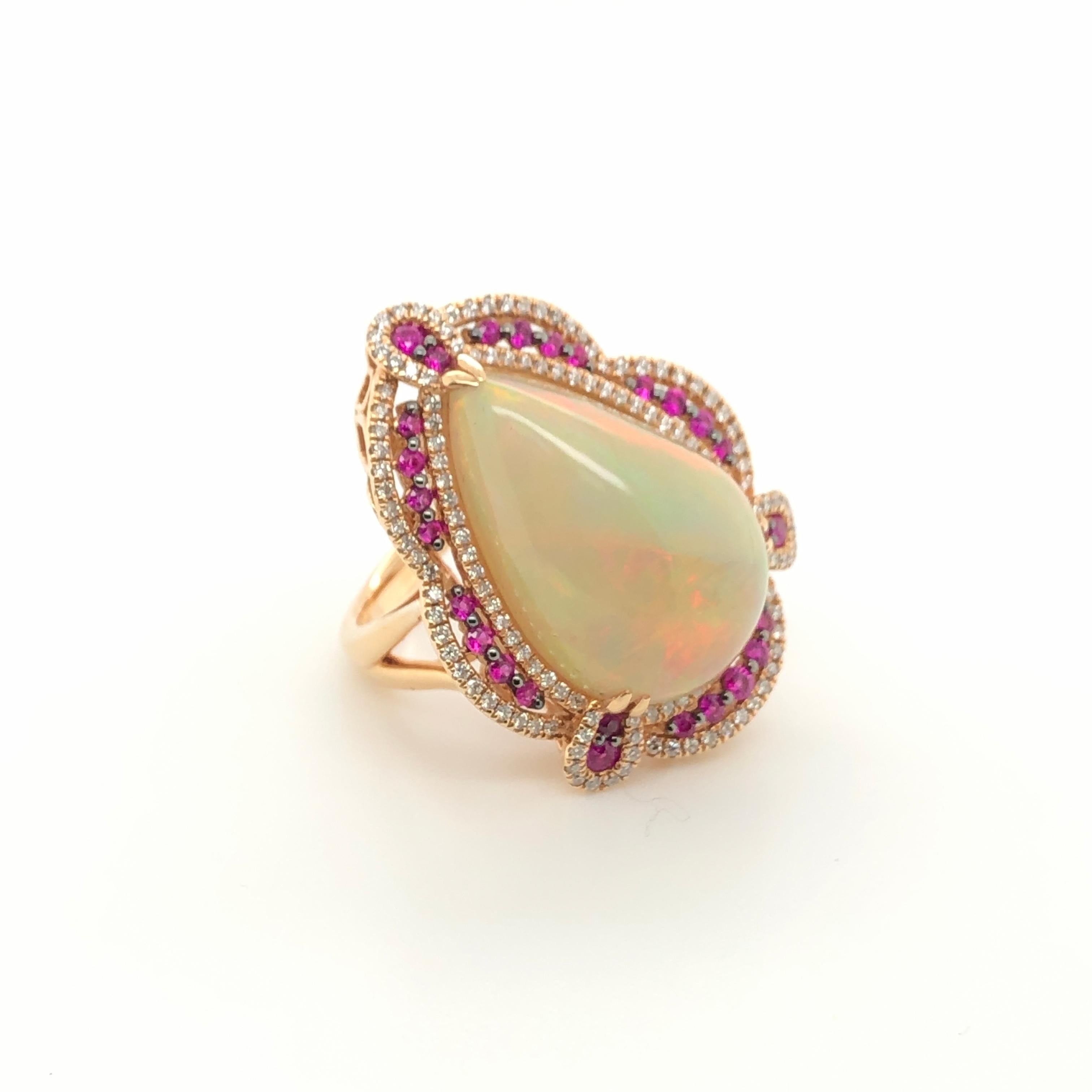 A gorgeous 13-1/4 carat pear-shaped Neopolitan Opal shimmers from within a contrasting border of Passion Rubies (1/2 ct. t.w.) and sparking Vanilla Diamonds (5/8 ct. t.w.) in this 18K Strawberry Gold ring from Le Vian Couture. A  single Chocolate