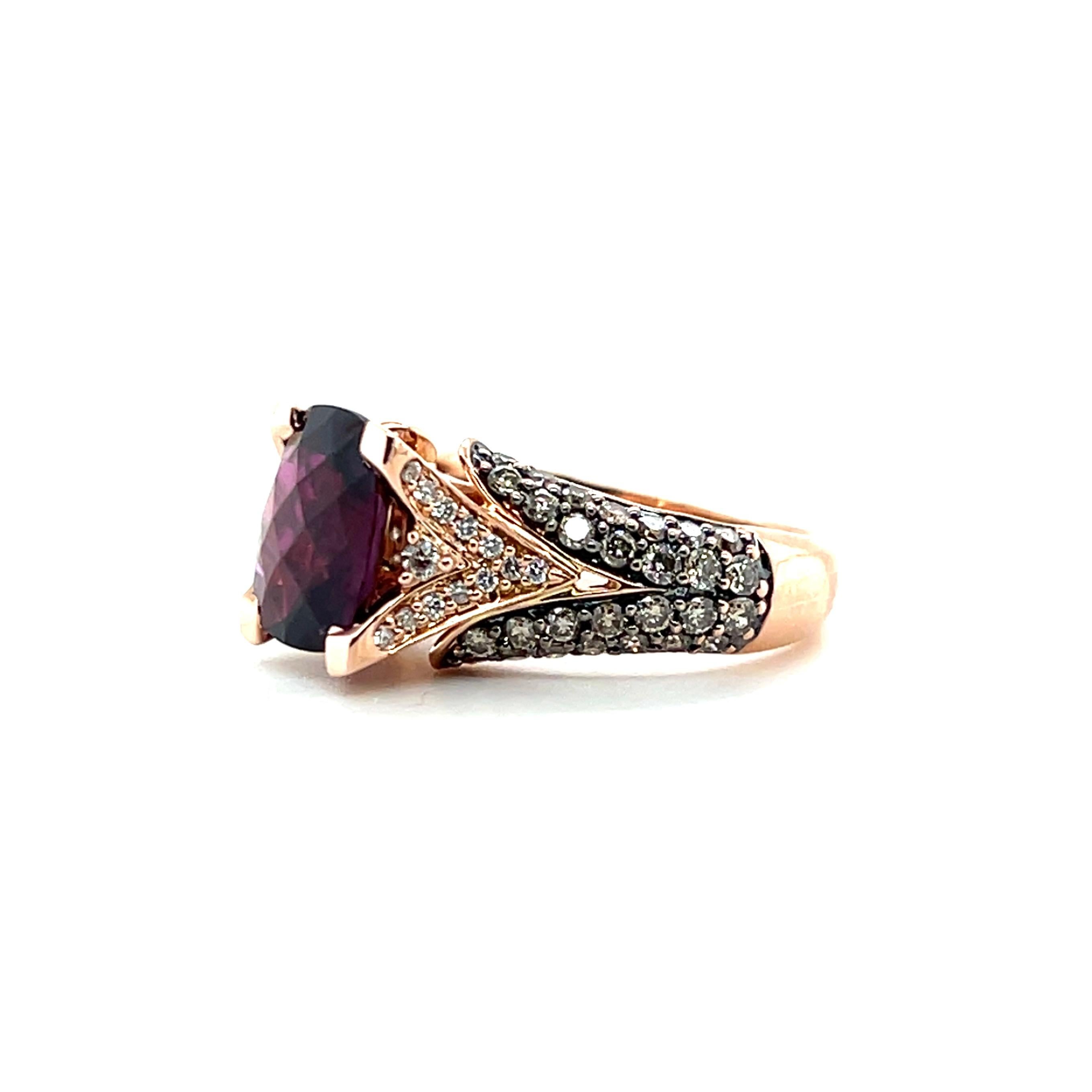 This contemporary 14 karat rose gold Le Vian ring features a 3.45-carat cushion-cut rhodolite garnet, a gemstone admired for its rich raspberry to purplish-red hue. The garnet is complemented by fifty-six round brilliant diamonds, approximately 1.01