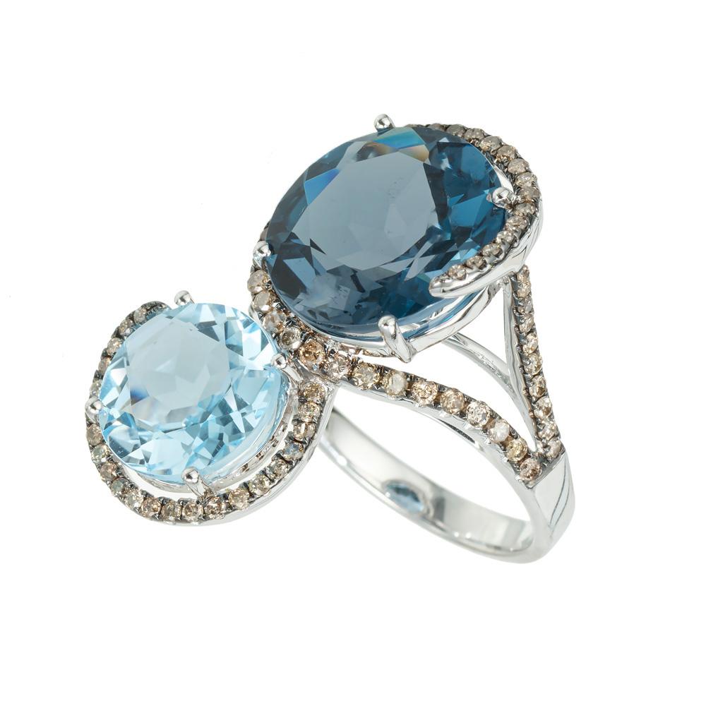 Topaz and diamond cocktail ring. Another unique creation by the designers at Le Vian. One round deep blue topaz totaling 6.50cts complimented with a smaller round light blue topaz totaling 2.20cts. Both gemstones are accented with light brown