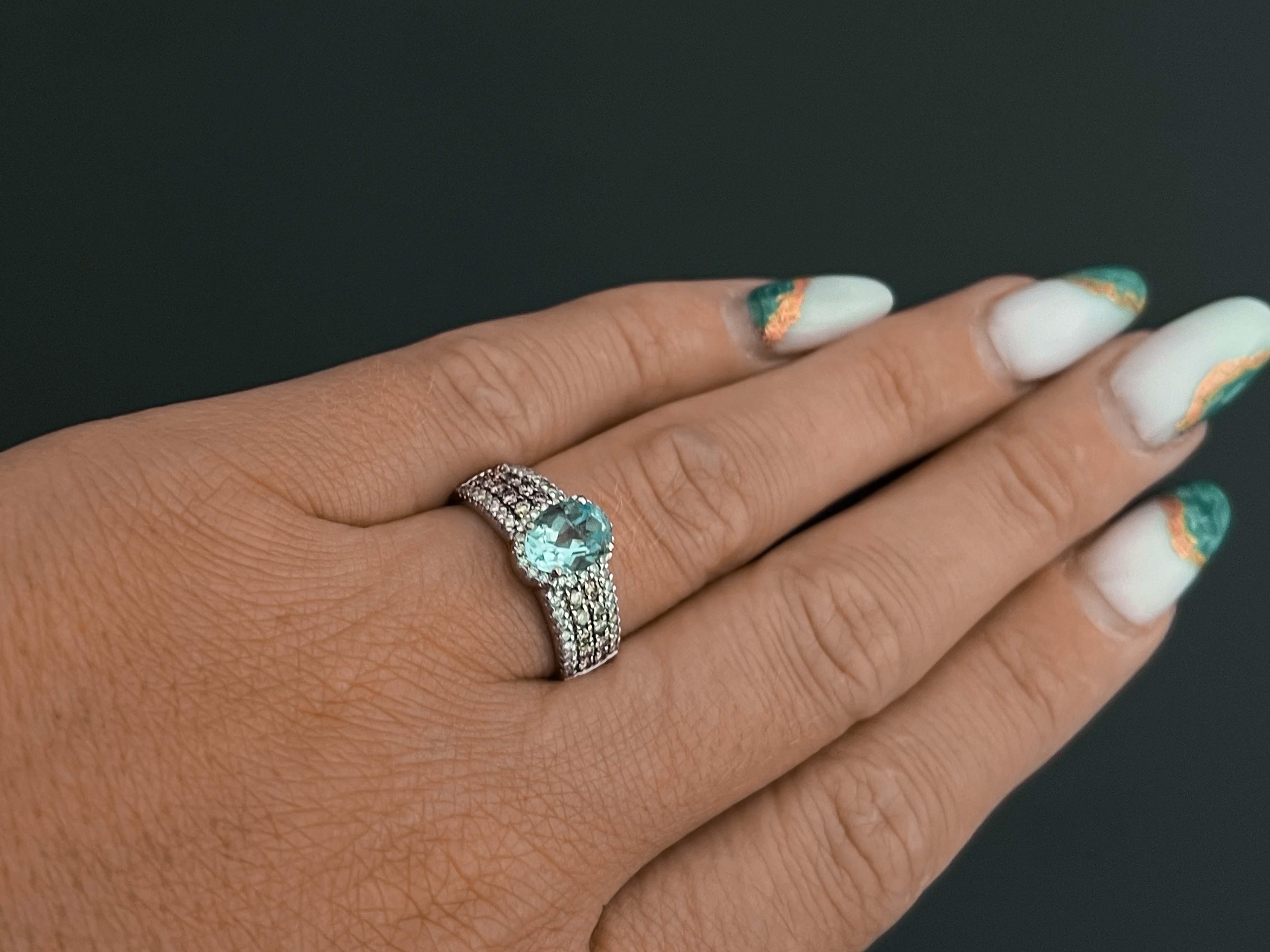 LeVian Aquamarine and Diamond Statement Ring in 14k White Gold. The band features a stunning oval baby blue 1 carat aquamarine faceted stone prong set and surrounded by a 20 diamond halo. The band of the ring features 4 rows of diamonds, the inside