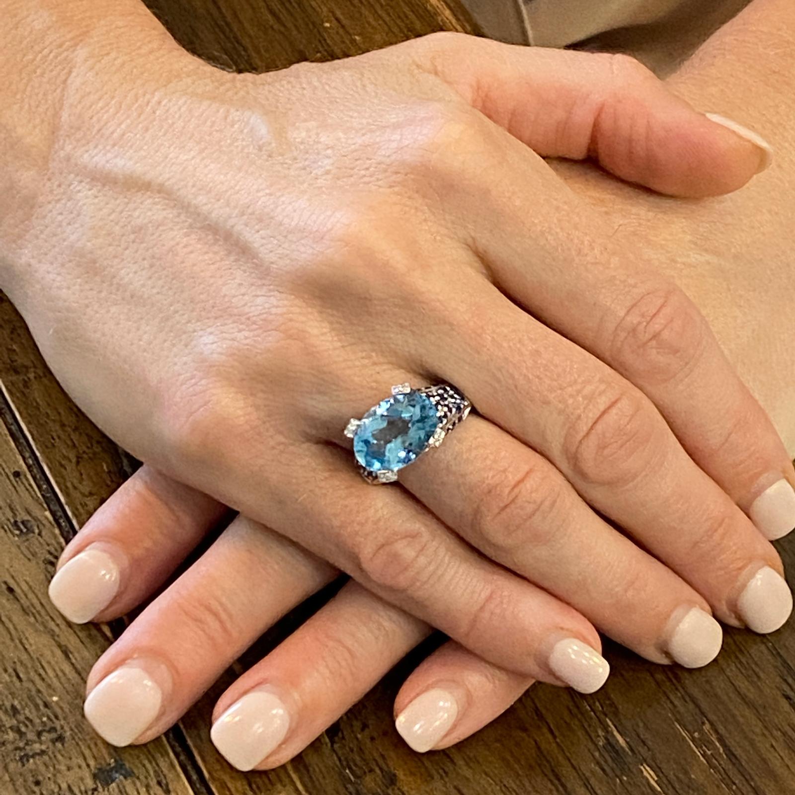 Diamond, blue topaz, and sapphire ring fashioned in 14 karat white gold. Designed by Le Vian, the ring features an approximately 6.00 carat oval faceted blue topaz gemstone set with 20 round brilliant cut diamonds and 50 blue sapphire accents. The
