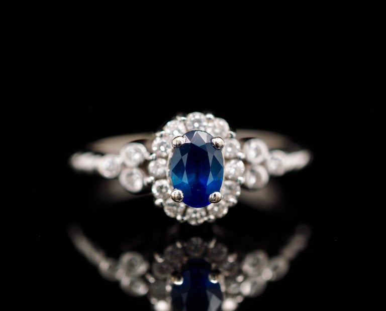 A gorgeous Le Vian contemporary style ring. It will make a perfect engagement ring or an exquisite fashion ring. The natural blueberry sapphire center is accompanied with a brilliant diamond halo along with a trio of bezel-set Diamondsn that are