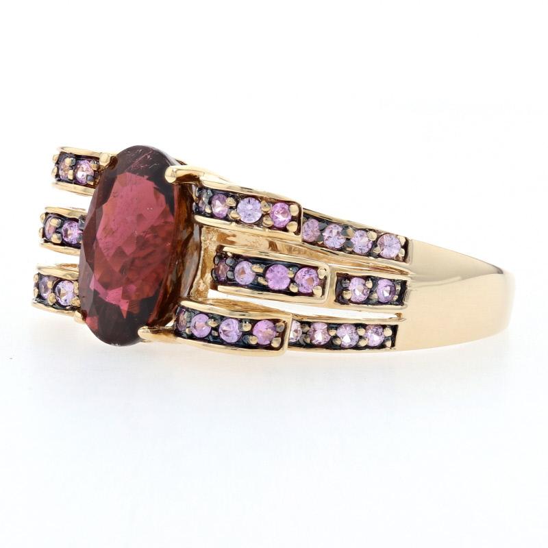 Artistically designed and set with sparkling gemstones, this Le Vian creation will be an exceptional addition to your collection! This 14k yellow gold ring hosts a majestic rubellite tourmaline solitaire featured between three curved 