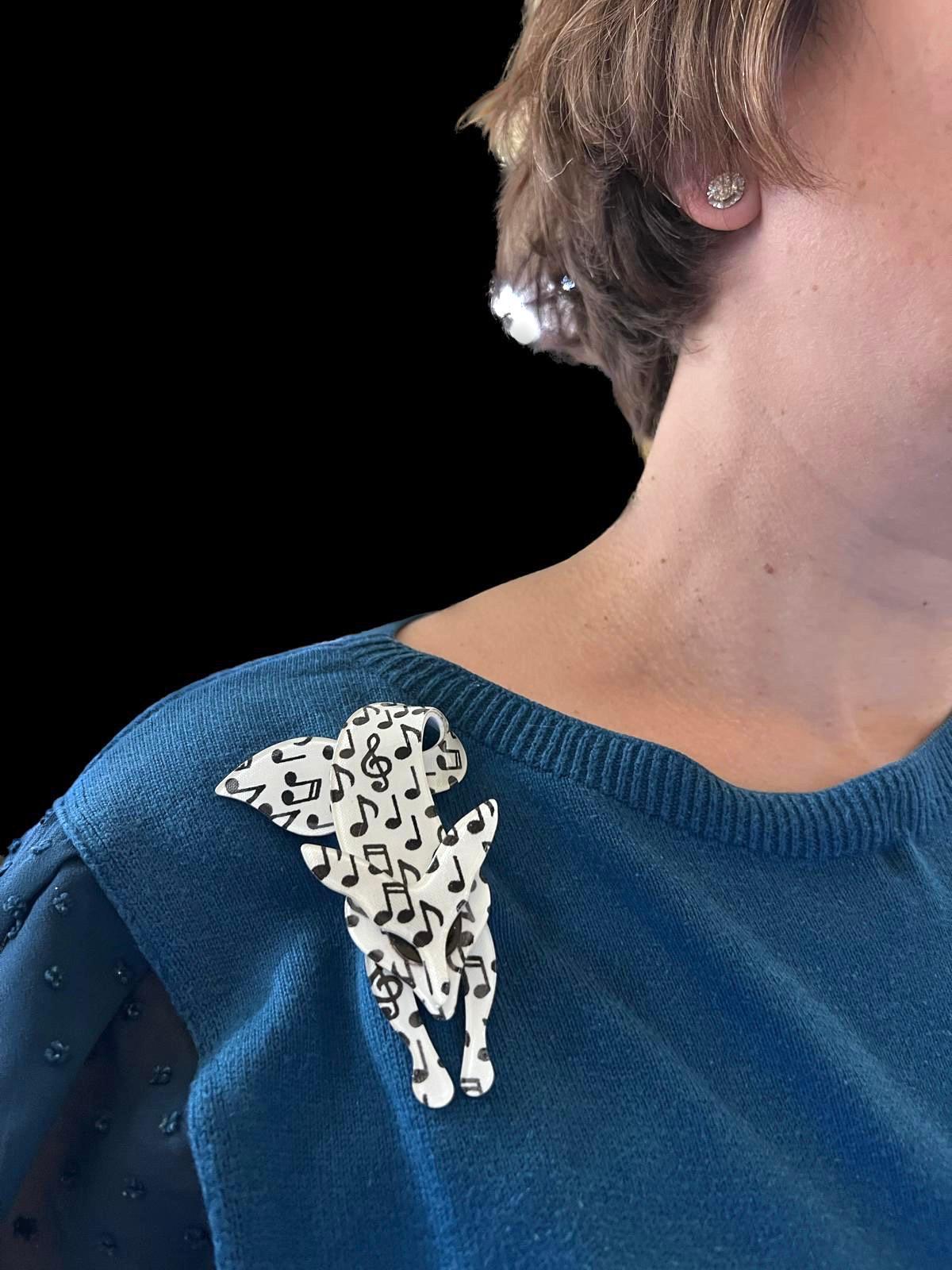 Broche en renard de Lea Stein avec motif de notes de musique en noir et blanc. 

Fabriqué à partir d'acétate de cellulose laminé, roulé à la main pour obtenir une couche mince et incurvée. 
Signé Lea Stein Paris sur l'épingle en métal au dos. Lea et