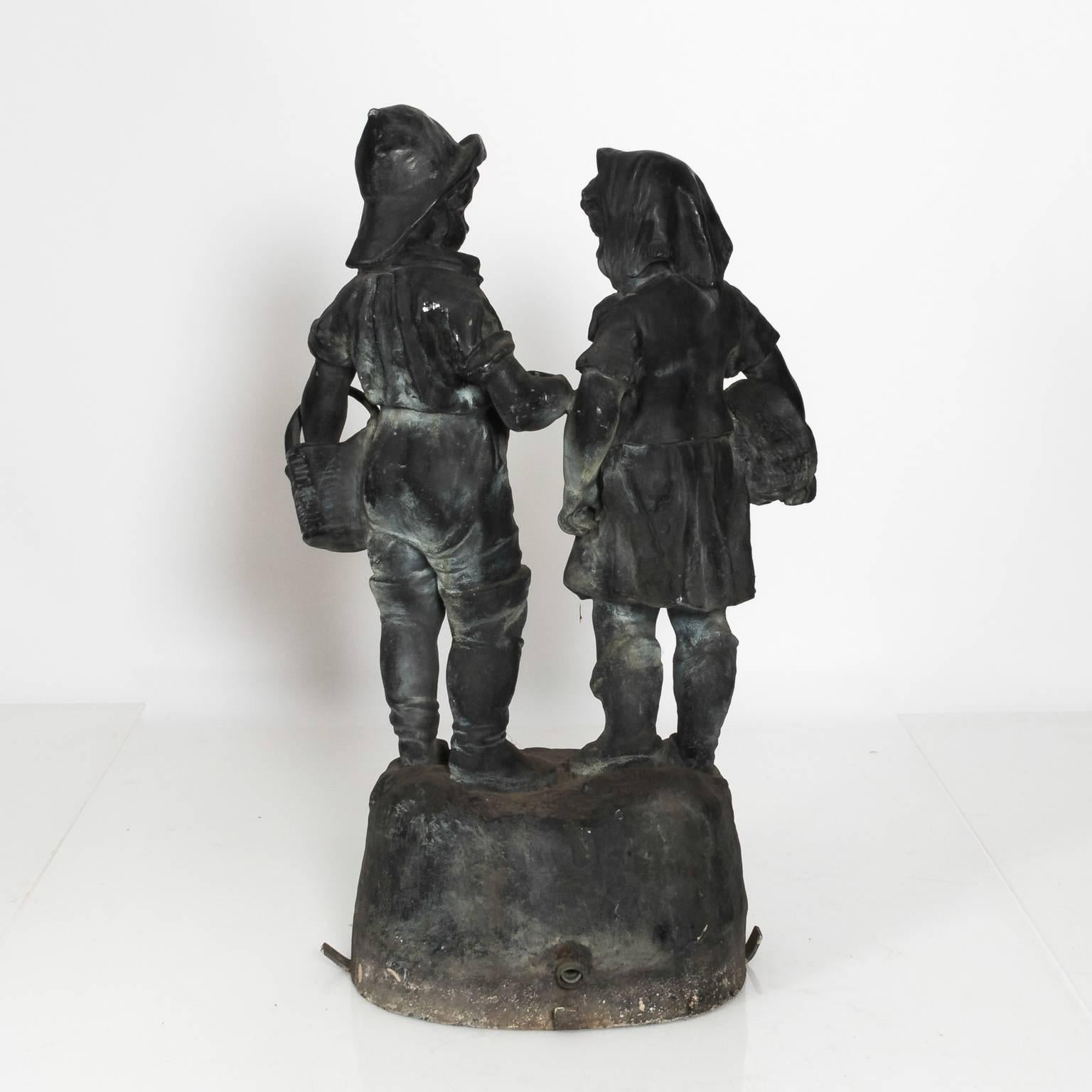 Lead fountain by J.W. Fiske that features a small boy and girl underneath an umbrella, circa early 20th century.
 
