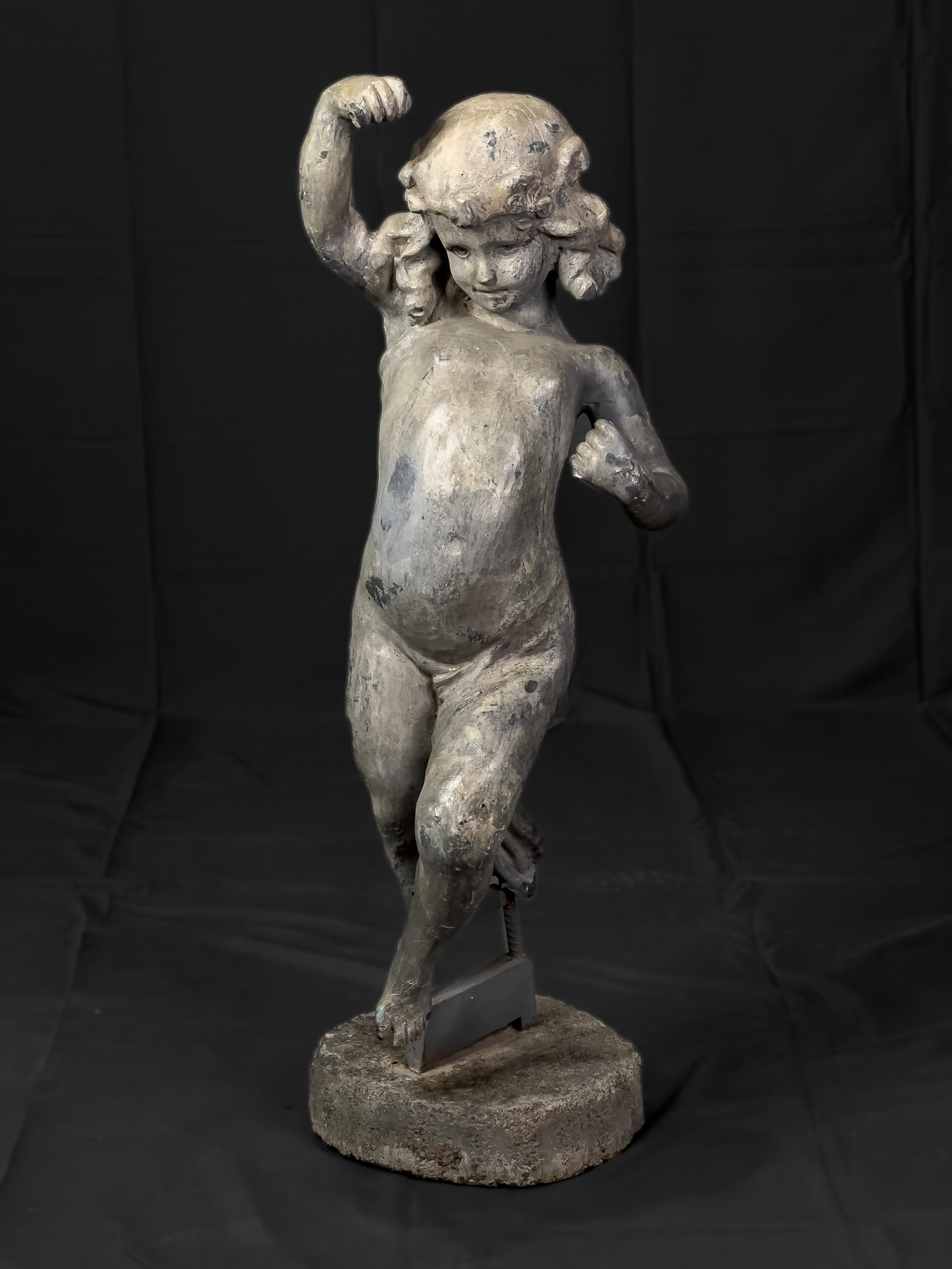 Early 20th century lead garden statue of a child frolicking outdoors. Originally might have been holding a ribbon that went from hand to hand, however the ribbon has been lost overtime. (No longer part of the statue).  

This item was part of 4