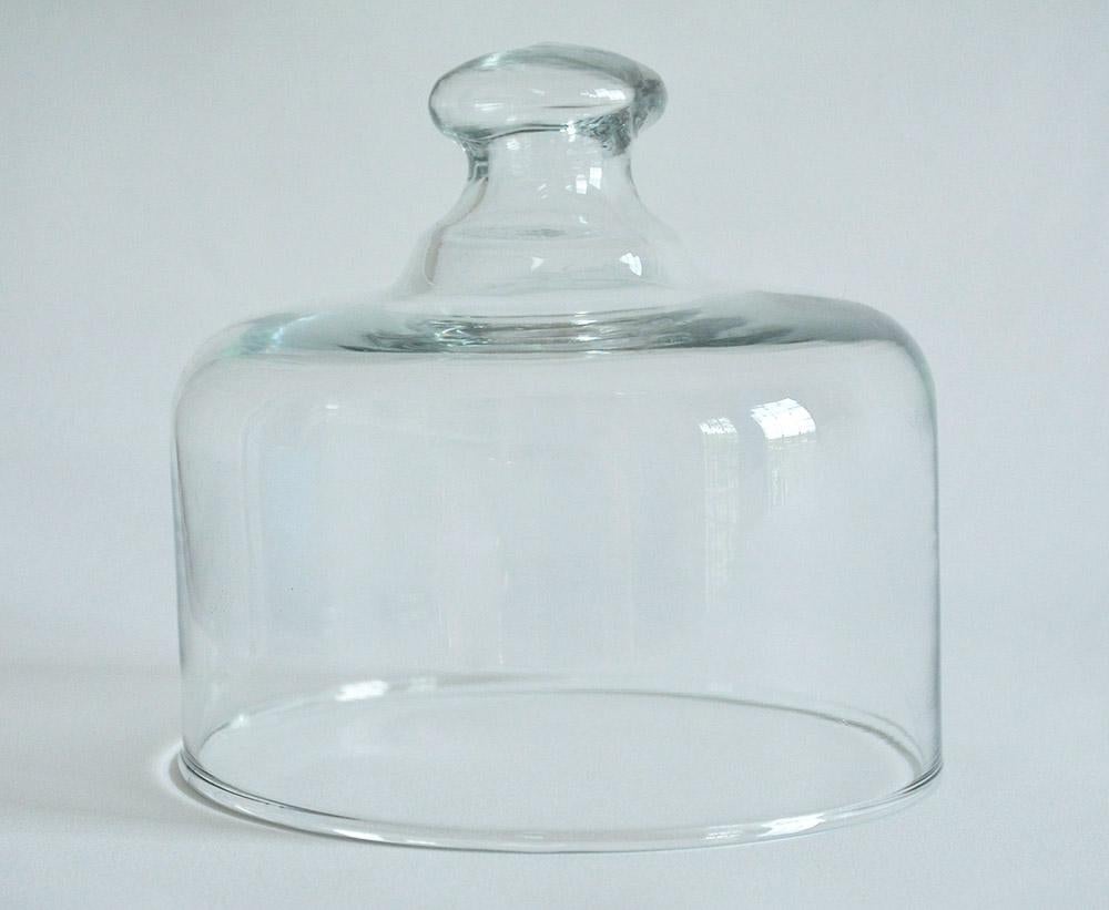 French patisserie glass cloche with an open glass knob handle. Smooth and polished glass, these were used in French patisseries. Bistros or home to cover and display pastries and cheese. Simple yet elegant, a wonderful addition to any table, kitchen