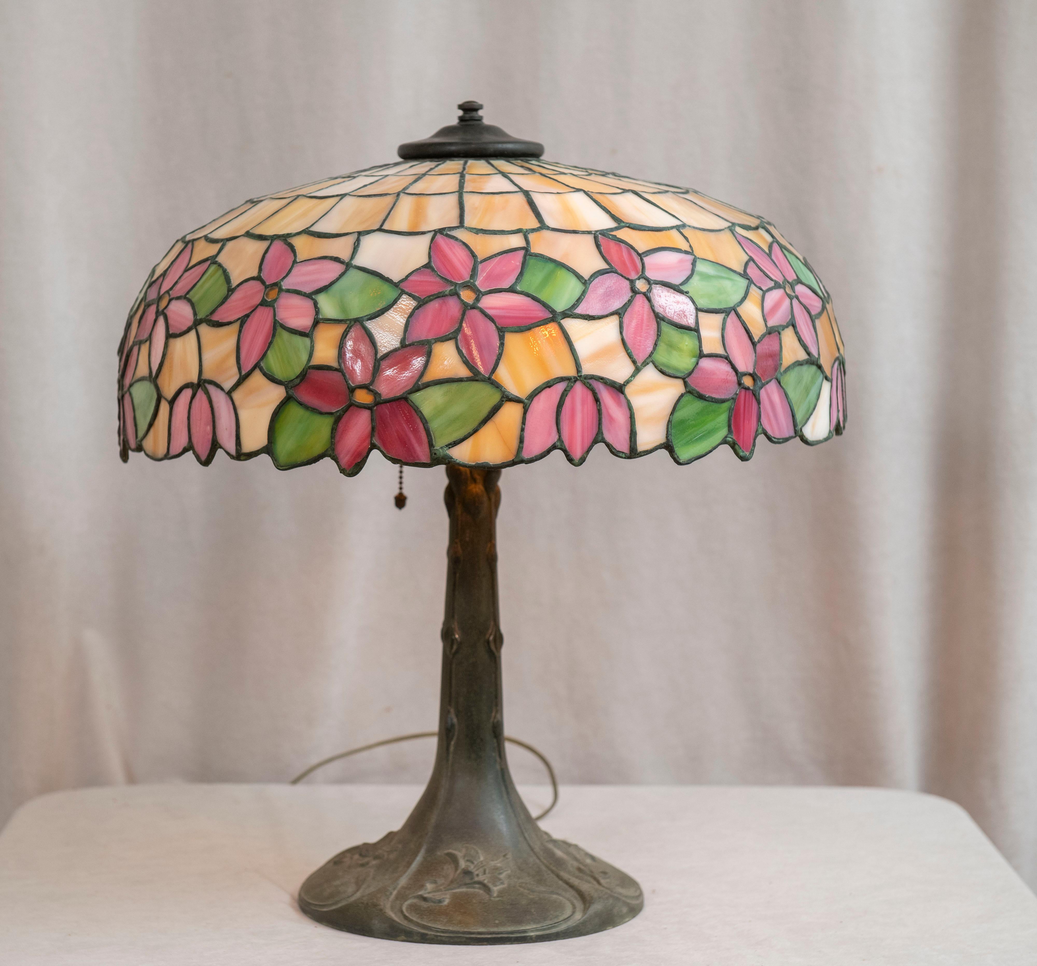  A very nice clean example of a leaded glass table lamp from the early part of the 20th century. The lamp was made by Lamb Bros. The ring on the top of the shade was done by Lamb Bros. The heat cap and finial are also the work of Lamb Bros. It's an
