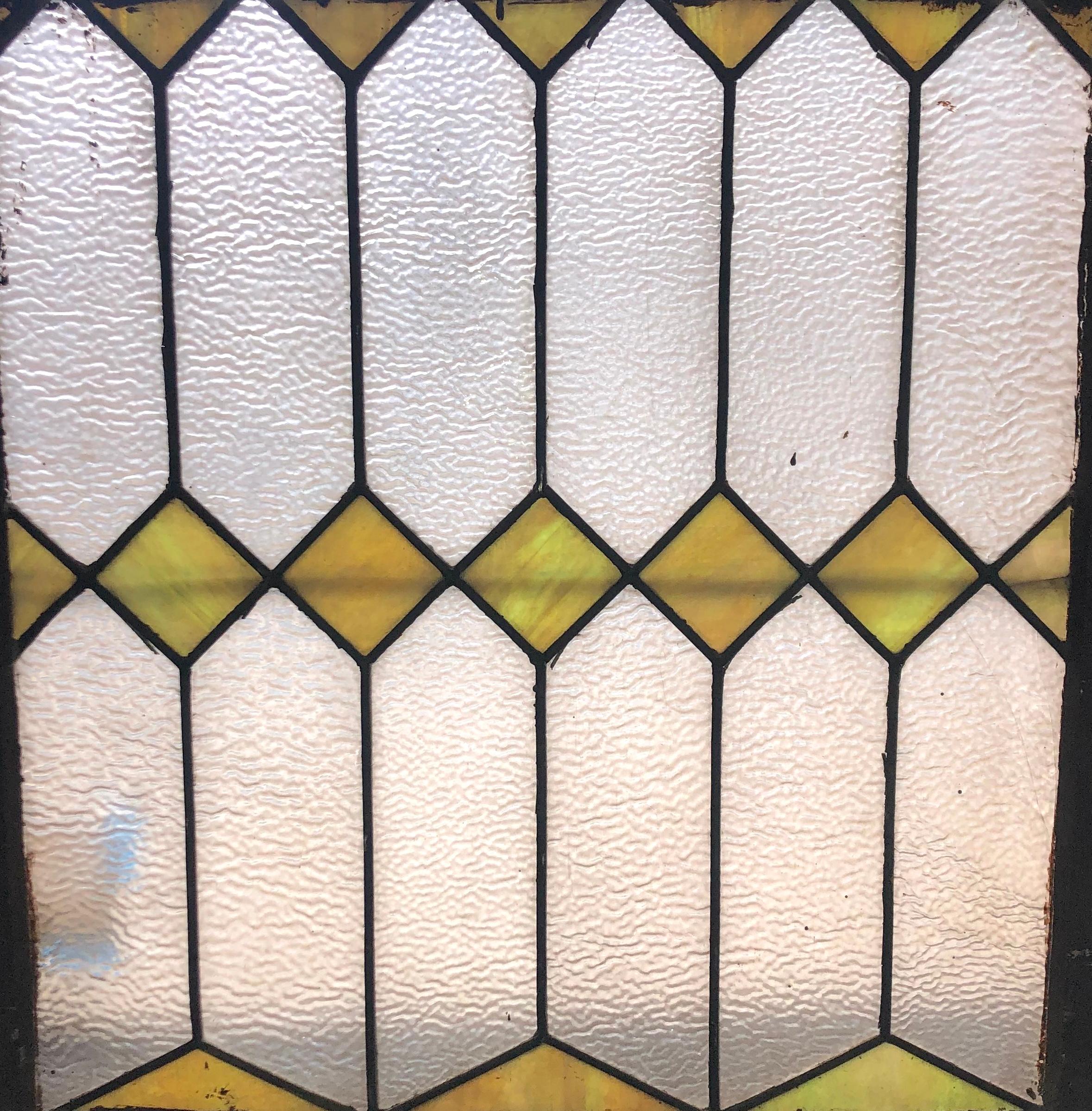 Vintage window with textured glass and geometric yellow stained glass. 
Currently housed in a wooden frame - the overall dimensions are for the stained glass and the frame.
Located in NY