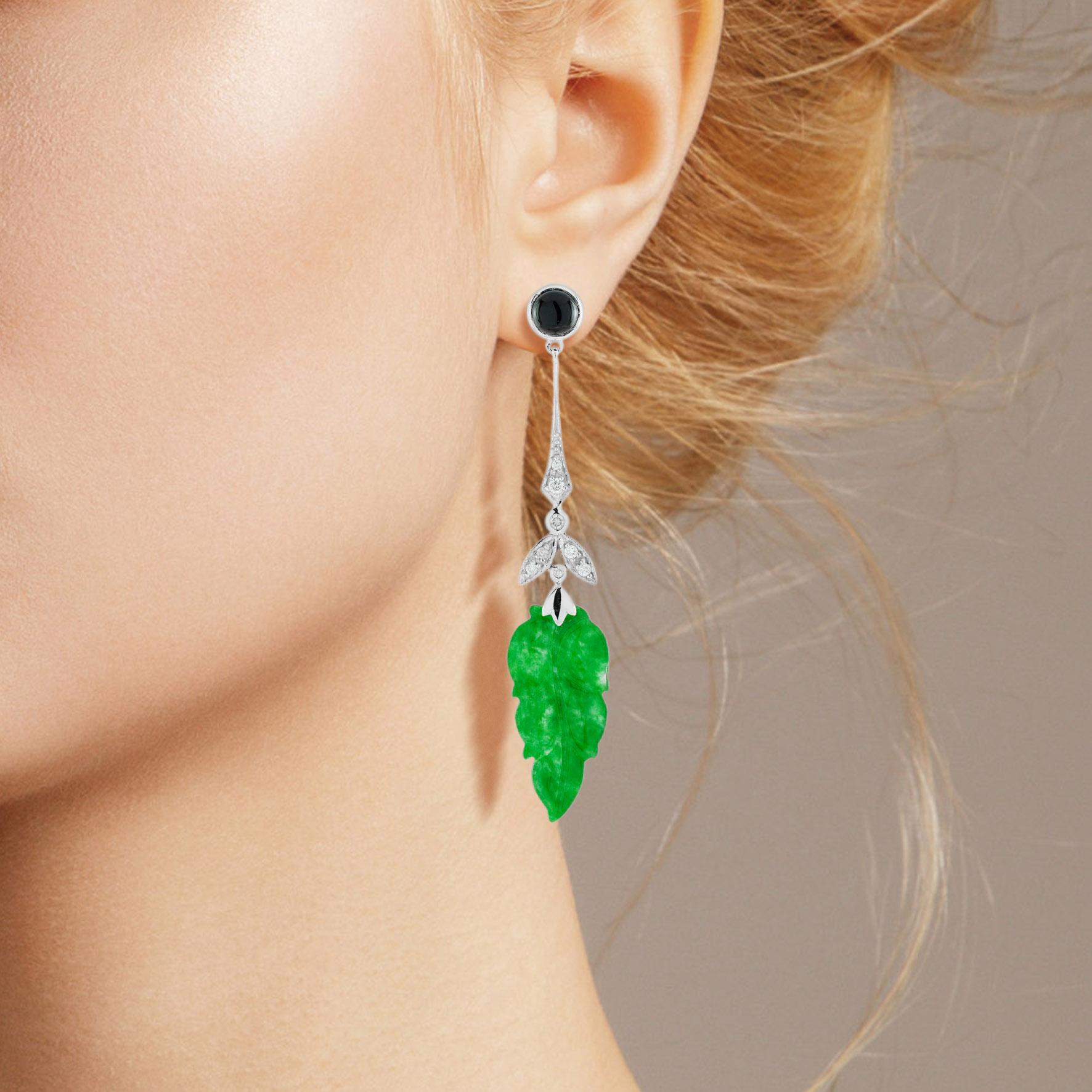The natural jade in these lovely earrings has some very special shape. Both pieces have a strong green color and well leaf carvings. The jade is suspended in a 9k white gold setting with diamond leaf and round onyx on the top. The earrings transfer