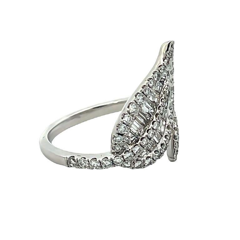 This exquisite fashion ring is a stunning example of masterful artistry and high-quality materials. The ring features an 18K white gold band with a beautiful leaf motif that adds a unique and eye-catching element to the design. The band is set with