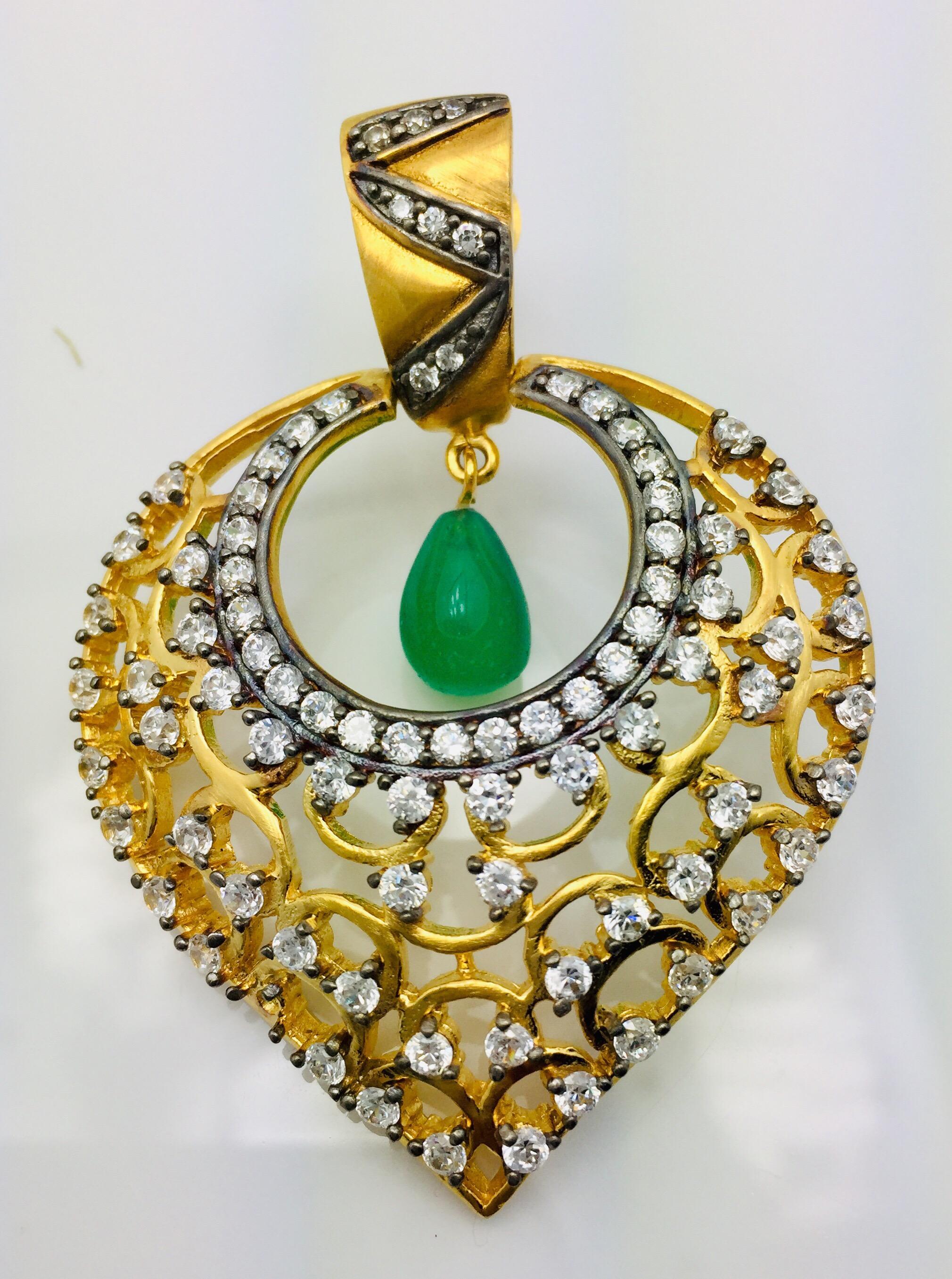 Foglia d'oro impreziosita da decine di pietre CZ scintillanti e orecchini a goccia con smeraldo finto. Questi orecchini sono in grado di soddisfare tutte le tendenze in un modo elegantemente bello. Gli orecchini hanno una chiusura a perno per le