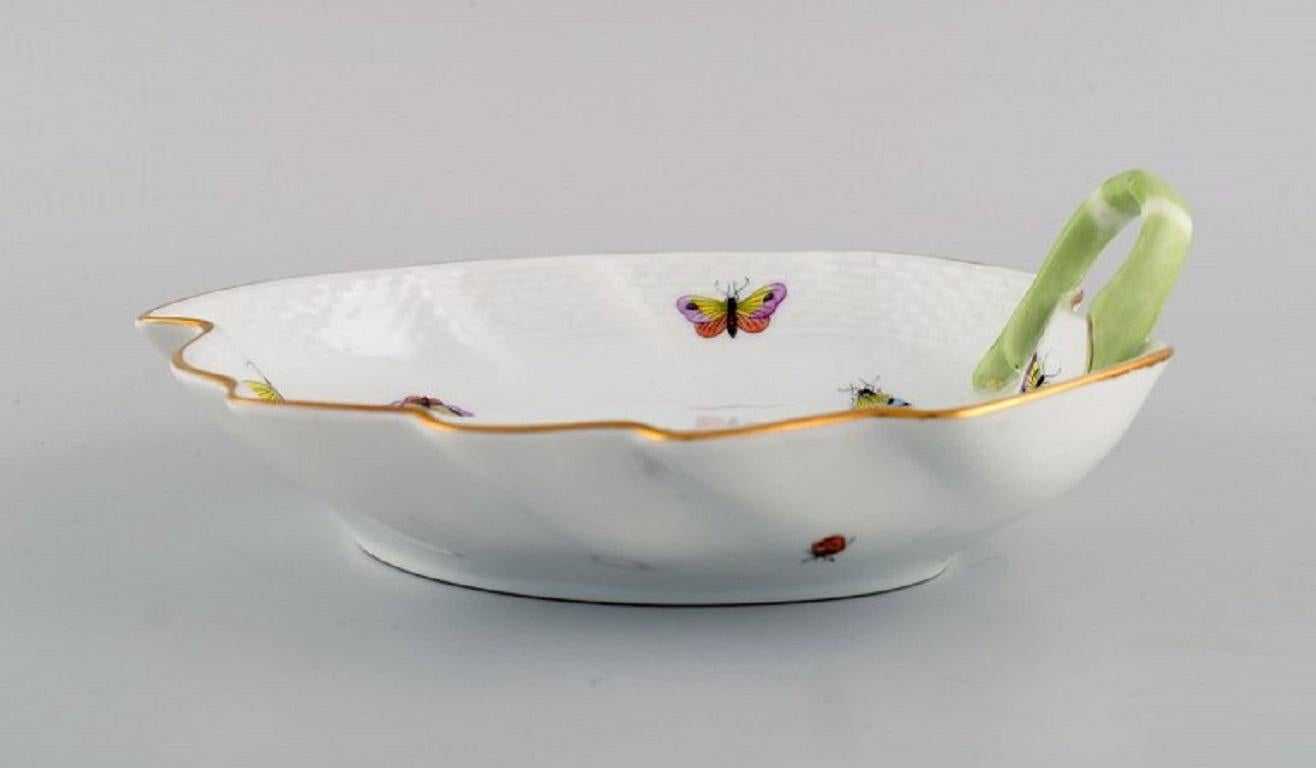 Plat en porcelaine Herend Rothschild en forme de feuille avec oiseaux, papillons et décoration dorée peints à la main. 
Milieu du 20e siècle.
Mesures : 20 x 7 cm.
En parfait état.
Estampillé.