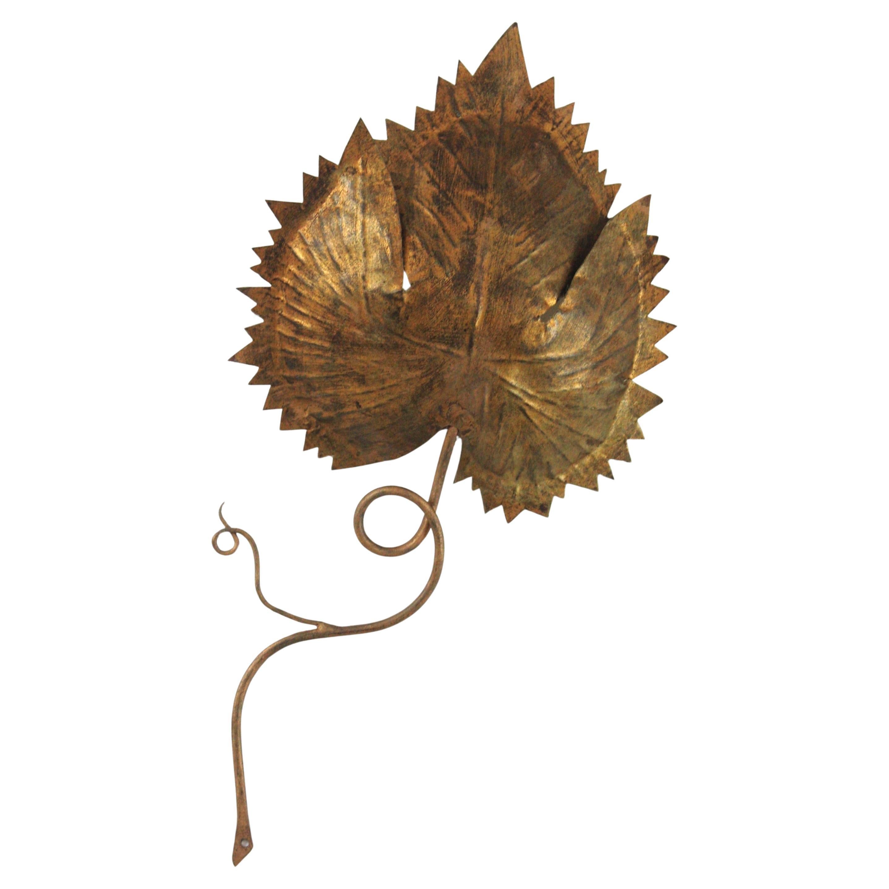 Spanish Leaf Shaped Wall Sconce in Gilt Iron, 1950s
Eyecatching handcrafted light fixture with leaf design and gold leaf gilt finish. It features a large leaf hidding the bulb socket.
Nicely hand-hammered piece, executed in gilt iron with a terrific
