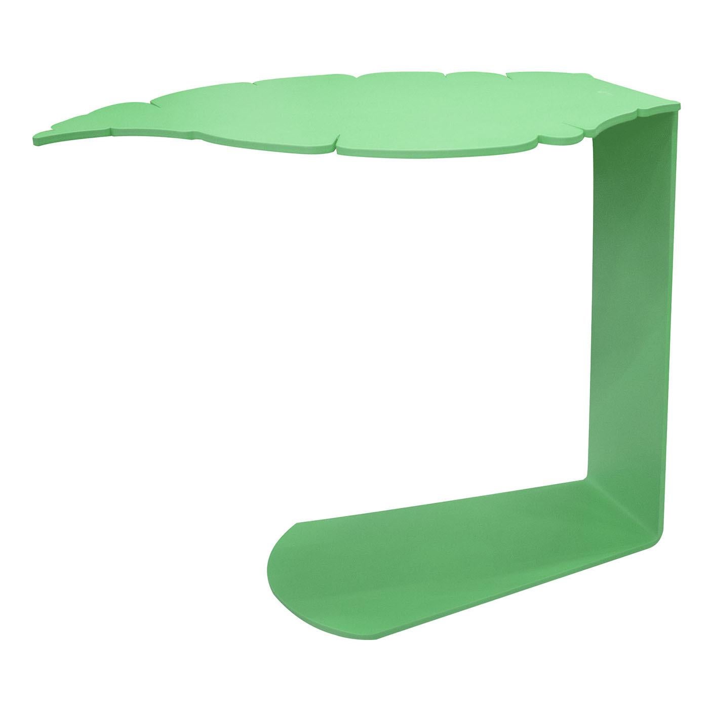 La table basse est fabriquée en métal et conçue en forme de feuille. Elle est découpée au laser et pliée pour obtenir sa forme complexe. La table présente une finition laquée vert mat, ce qui renforce son aspect moderne et élégant.