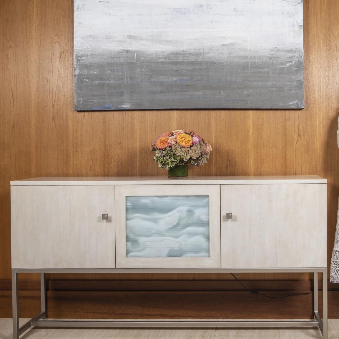 Exquisitely crafted, the Leah Cabinet will effortlessly complement any modern elegant interior space. Designed for entry spaces with an inspired mid-century look the Leah cabinet optimizes space, beauty, and light. Complete with white wave glass and