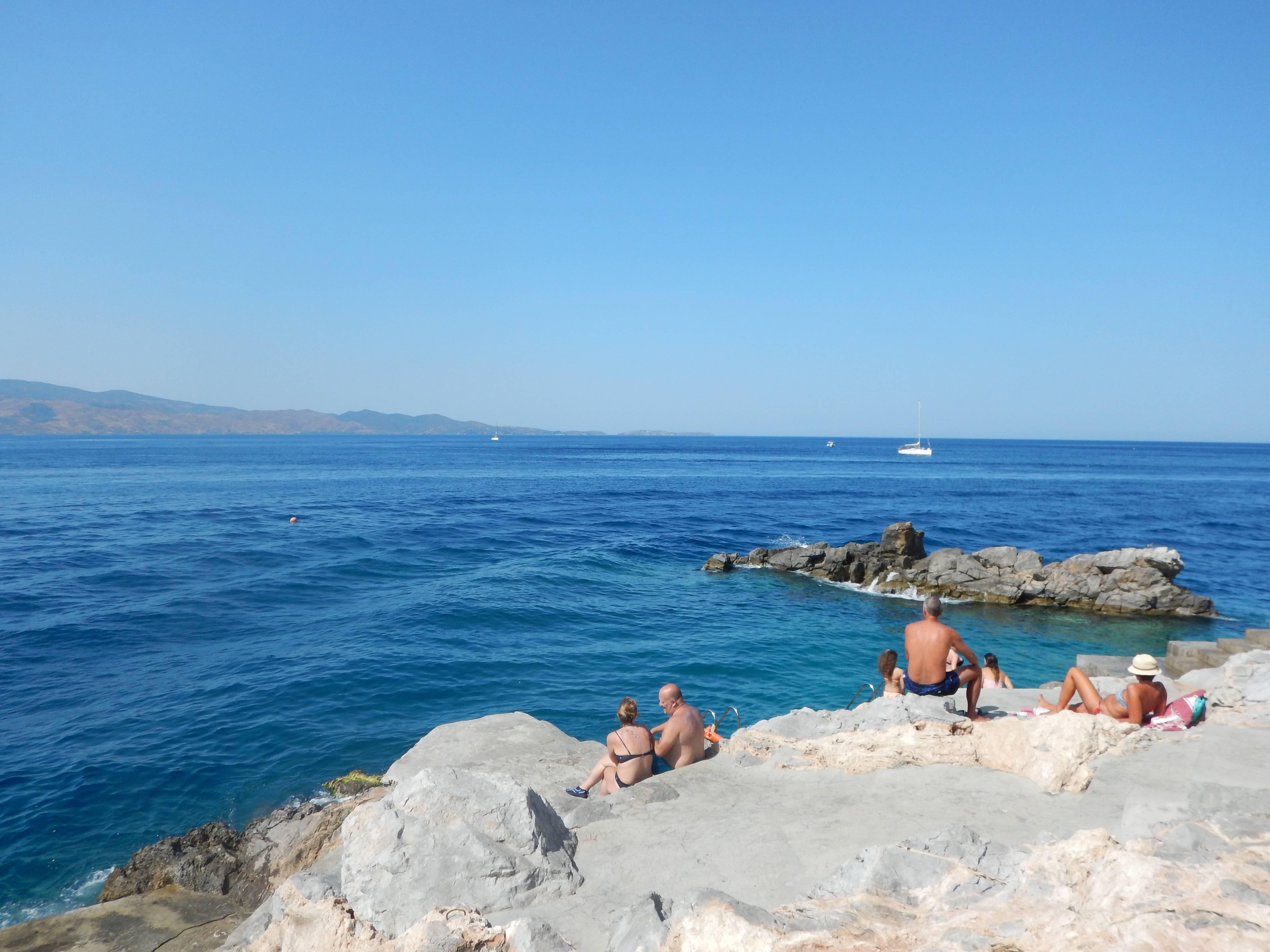 Sunbathers auf den Felsen in Spilia, Hydra, Griechenland