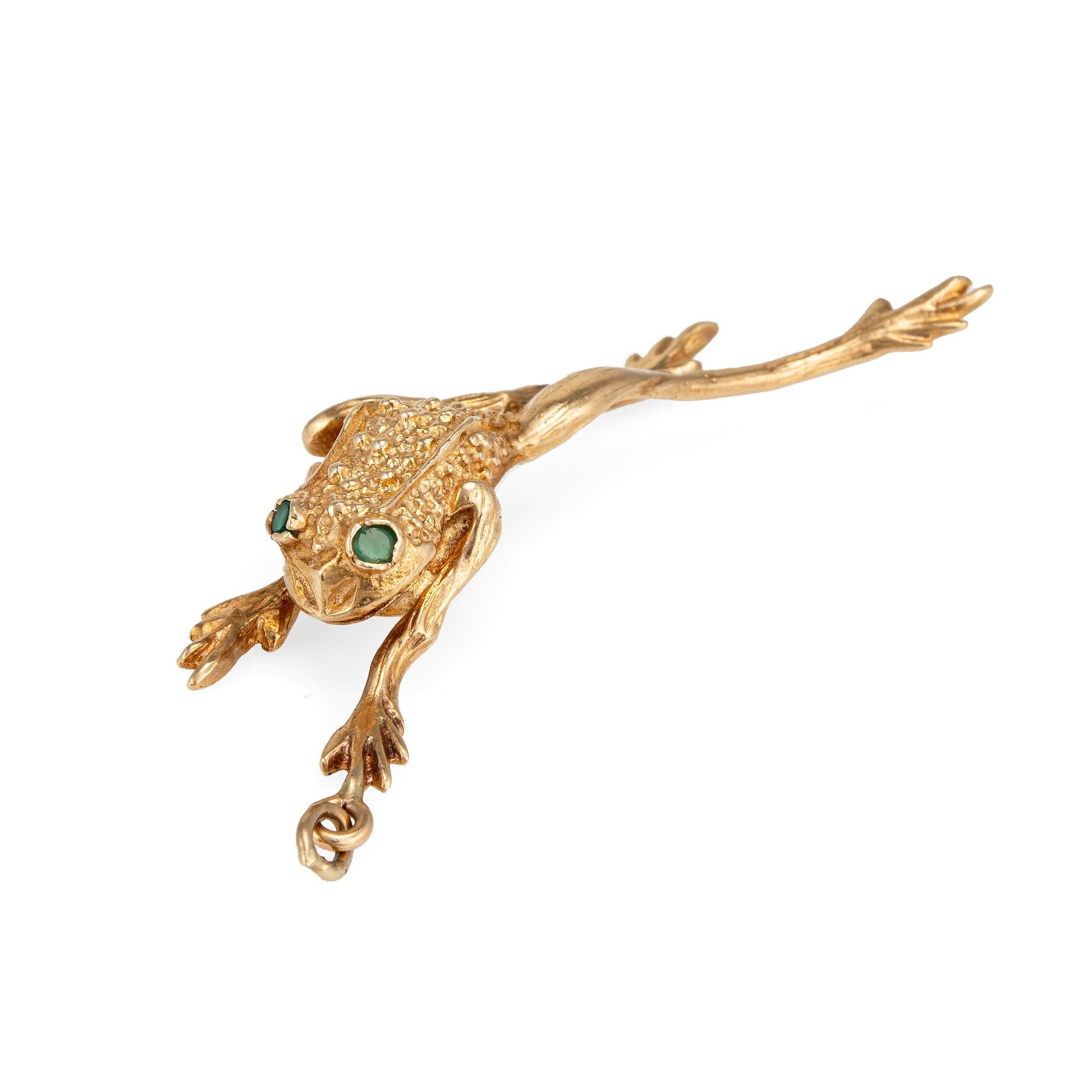 Finely detailed vintage frog pendant crafted in 14k yellow gold (circa 1960s to 1970s).  

Two estimated 0.02 carat emeralds are set into the eyes (0.04 carats total estimated weight). 

The charming & whimsical frog is crafted in a leaping position