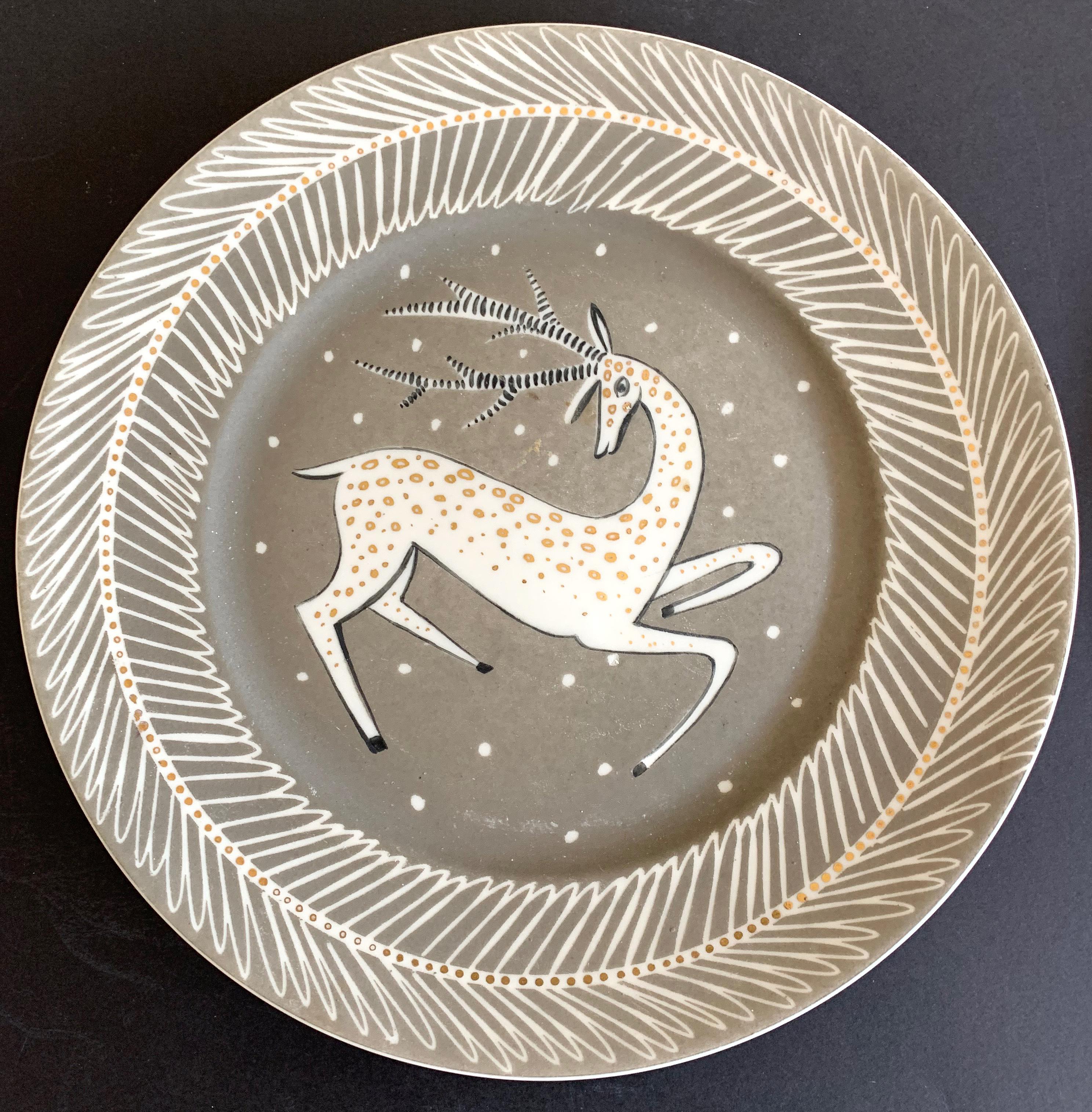 Gorgeously glazed in tones of warm grey (almost taupe), white and mirrored gold, this rare and stunning pair of plates depict leaping gazelles, a favorite motif of artists in the Art Deco era. The artist was Waylande Gregory, who was prodigious and