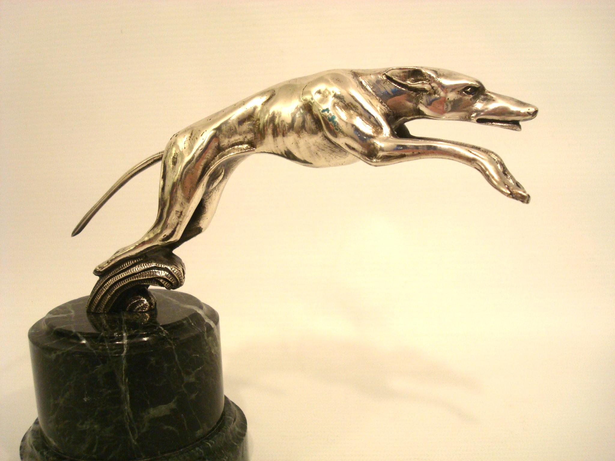 Scultura in bronzo del levriero che salta / fermacarte / ornamento per il cappuccio. c.1925 

Cane in bronzo argentato montato su una base di marmo verde.
Perfetto per qualsiasi scrivania.
Assomiglia molto a un ornamento del cofano della Lincoln del