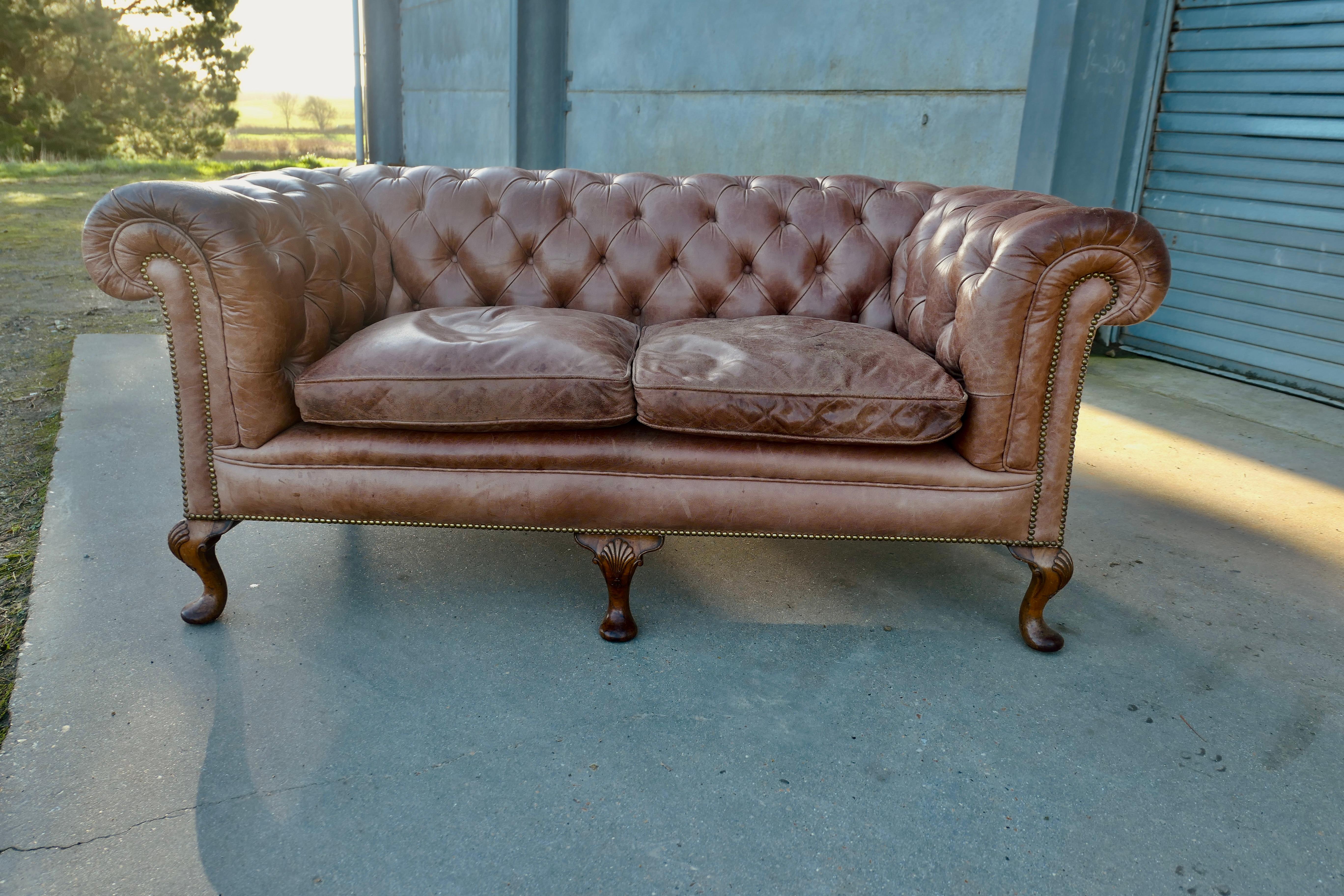Leather 2 Seater Library Chesterfield  Settee

This Settee is the ultimate in Vintage Country House Chic, it has a delightfully generous shape, and the leather upholstery is original with the great character and softness 
The legs are carved and