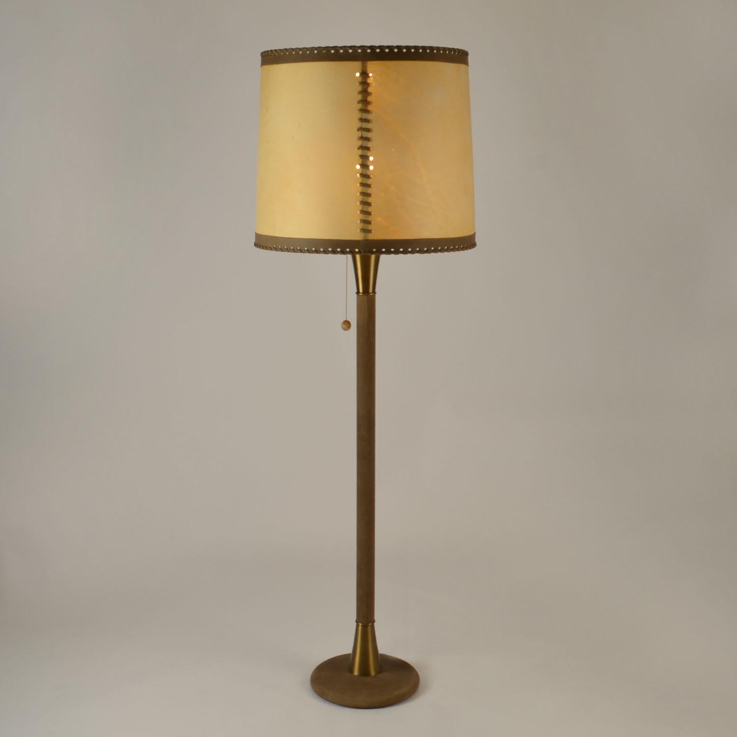 Elegante lampada da terra degli anni '60 in pelle marrone medio con ampio paralume in pelle di pergamena che crea una luce calda. Il paralume a tamburo realizzato a mano in pergamena è legato a bordi in pelle, cuciti a mano in pelle e collegati da