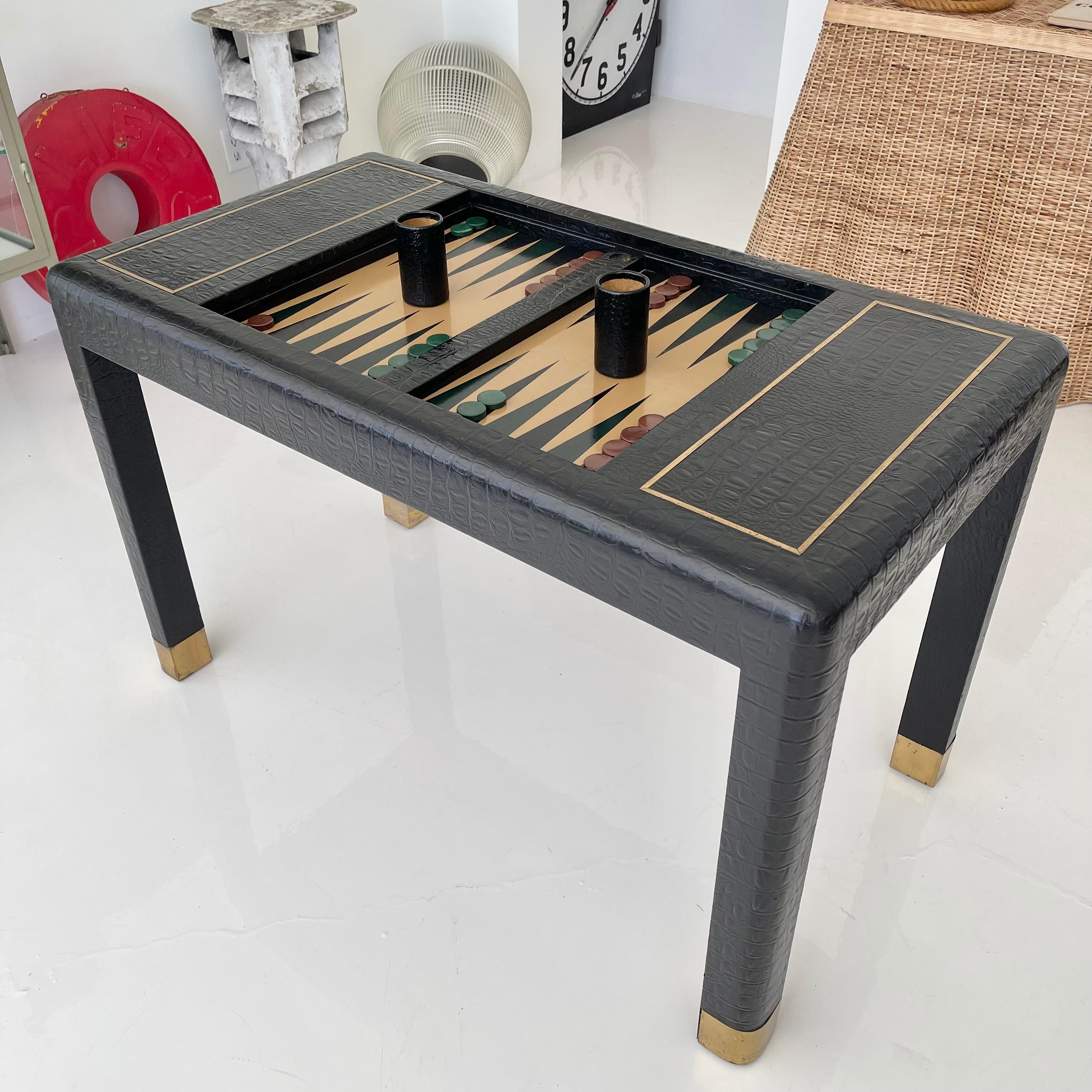 Vintage navy leather and brass backgammon table with removable cover. Stamped leather in the appearance of crocodile skin. Very heavy and substantial. Removable cover with brass trim. Leather game board with navy and green triangles. Hidden