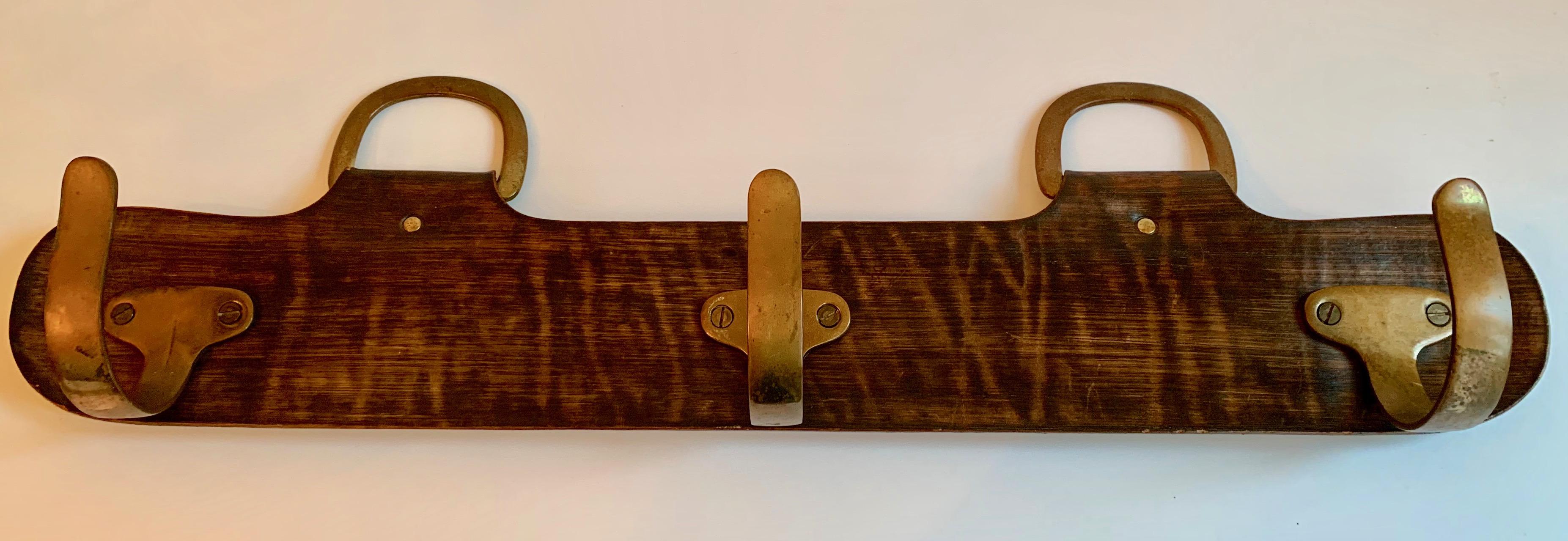 Leather and brass coat hook rack in the manner of Adnet - a handsome all leather band supporting three brass hooks with brass rings for application or decor - wonderful for the cabin, mud room, or rustic entry... or go modern!