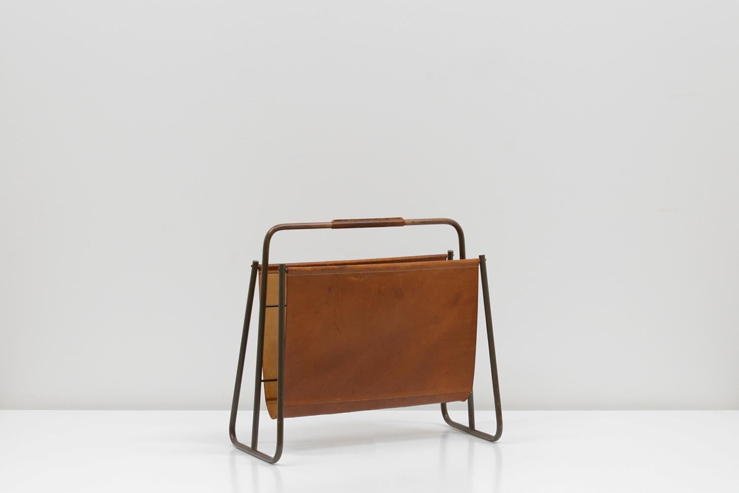 Leather and brass magazine rack by Carl Auböck for Auböck Werkstätte, Vienna 50s. Beautiful patinated brass frame and saddle leather. In very good vinage condition. 

 