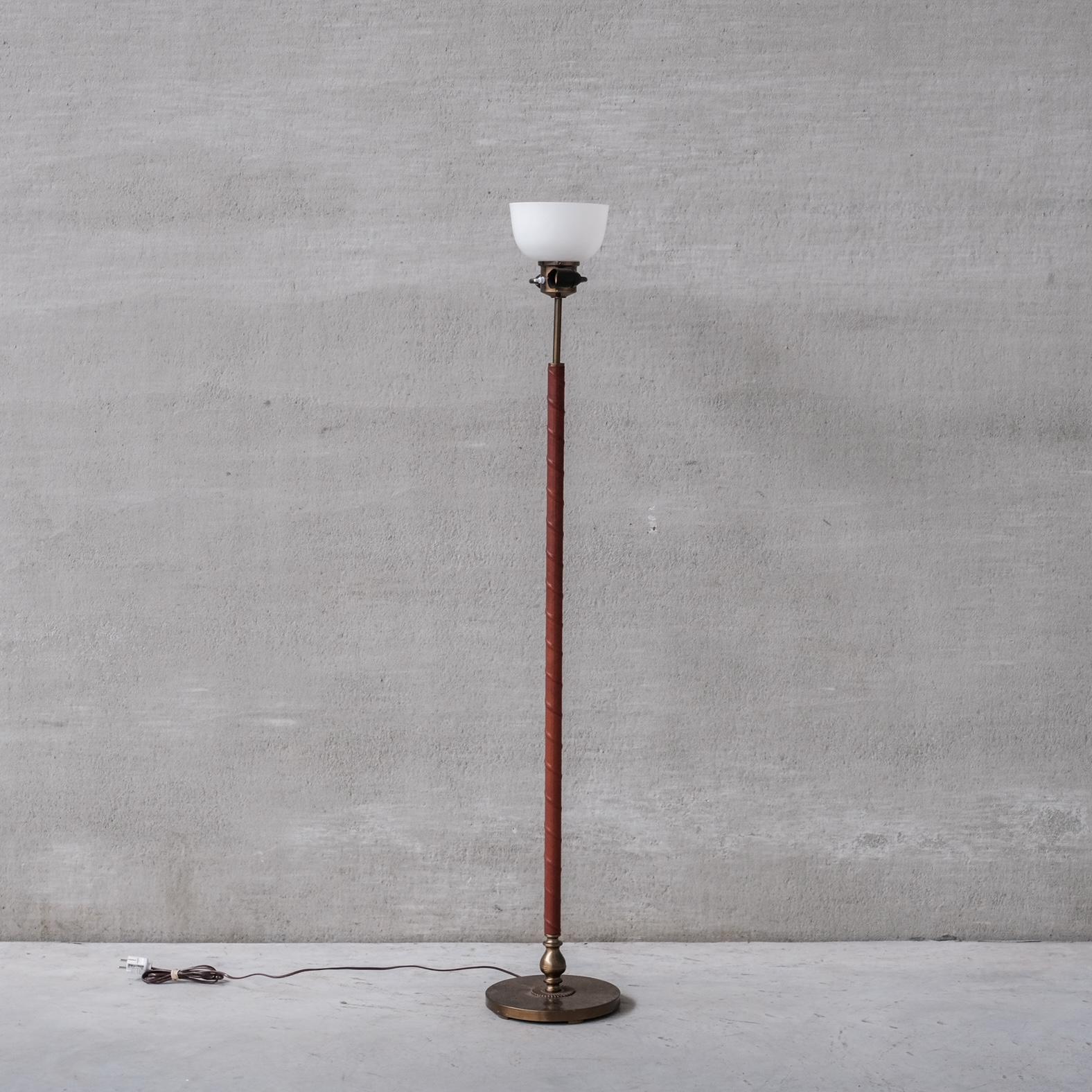 A floor lamp by Einar Bäckström. 

Sweden, circa 1950s. 

Brushed brass and leather. 

Original glass booster shade retained which would be the stability for a custom shade. We have a local shade maker we can recommend for a quote.