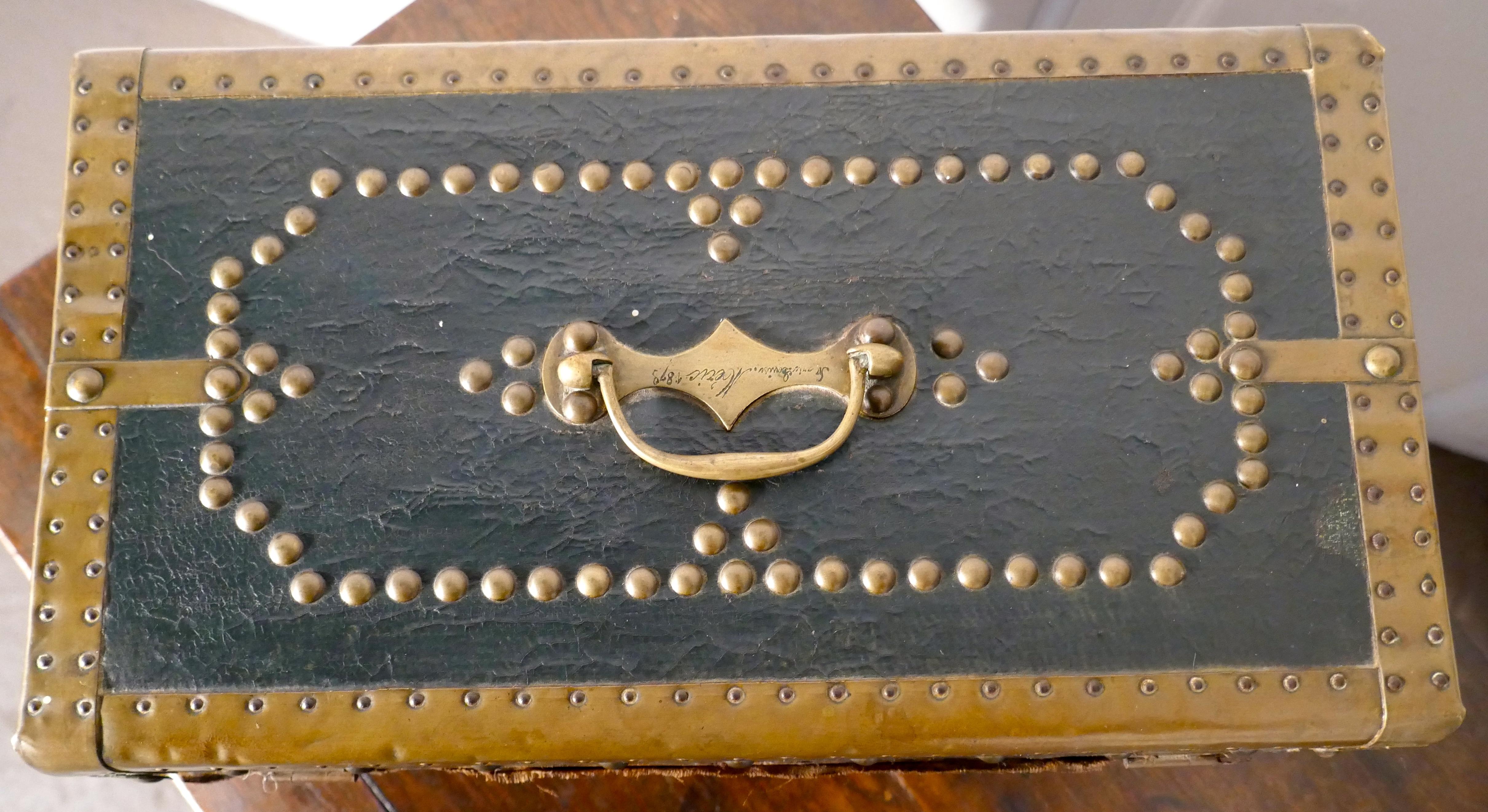 Leather and brass studded treasure chest or jewellery box 1878

This is a very attractive piece, it is leather covered and heavily bound in Brass with much brass stud work decoration, the chest has a top carrying handle and there is an inscription