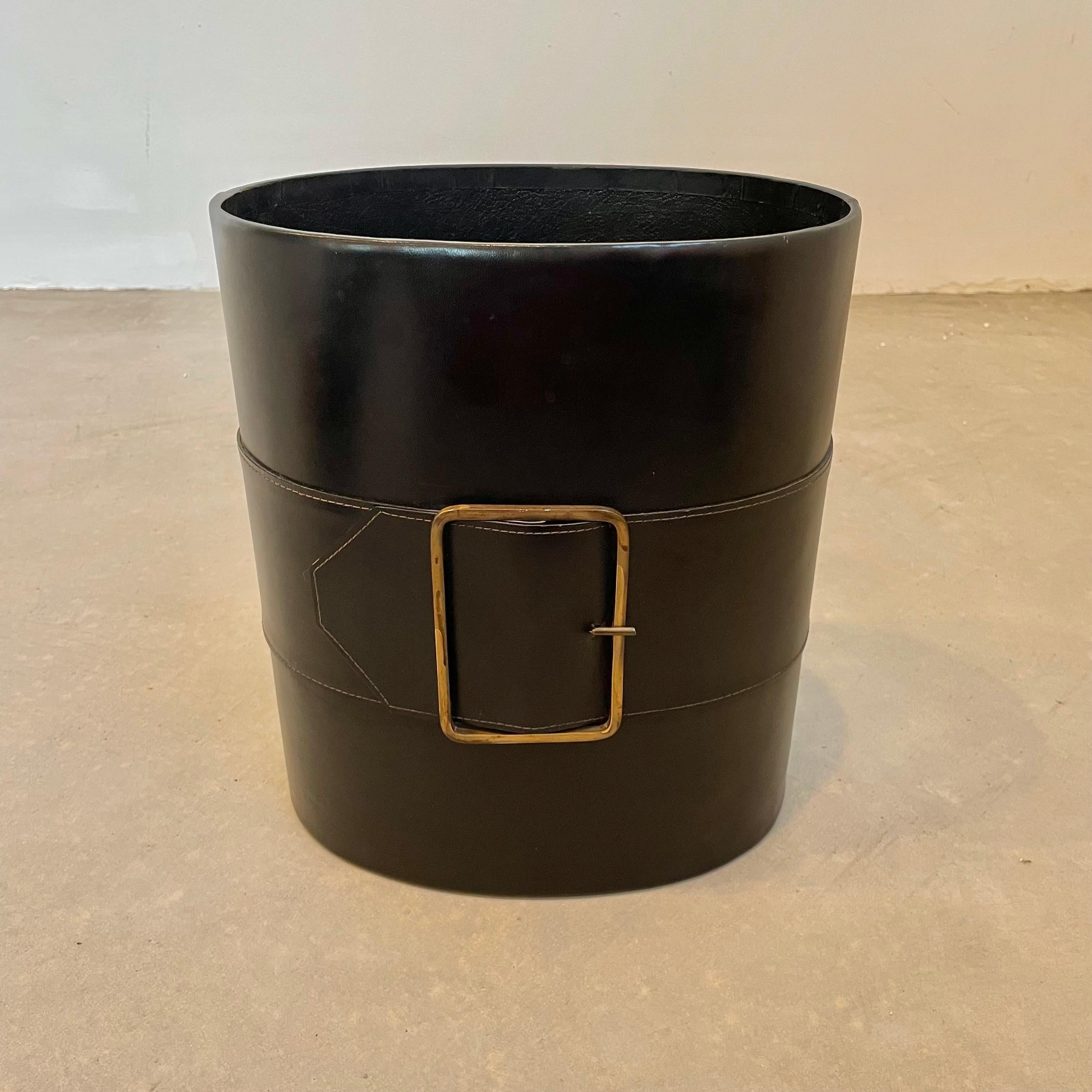 Beautiful black leather waste bin with an oversized strap and brass buckle running across the body. Sturdy cylindrical body with leather interior and base. Great color and good vintage condition. High quality materials that just get better with age. 