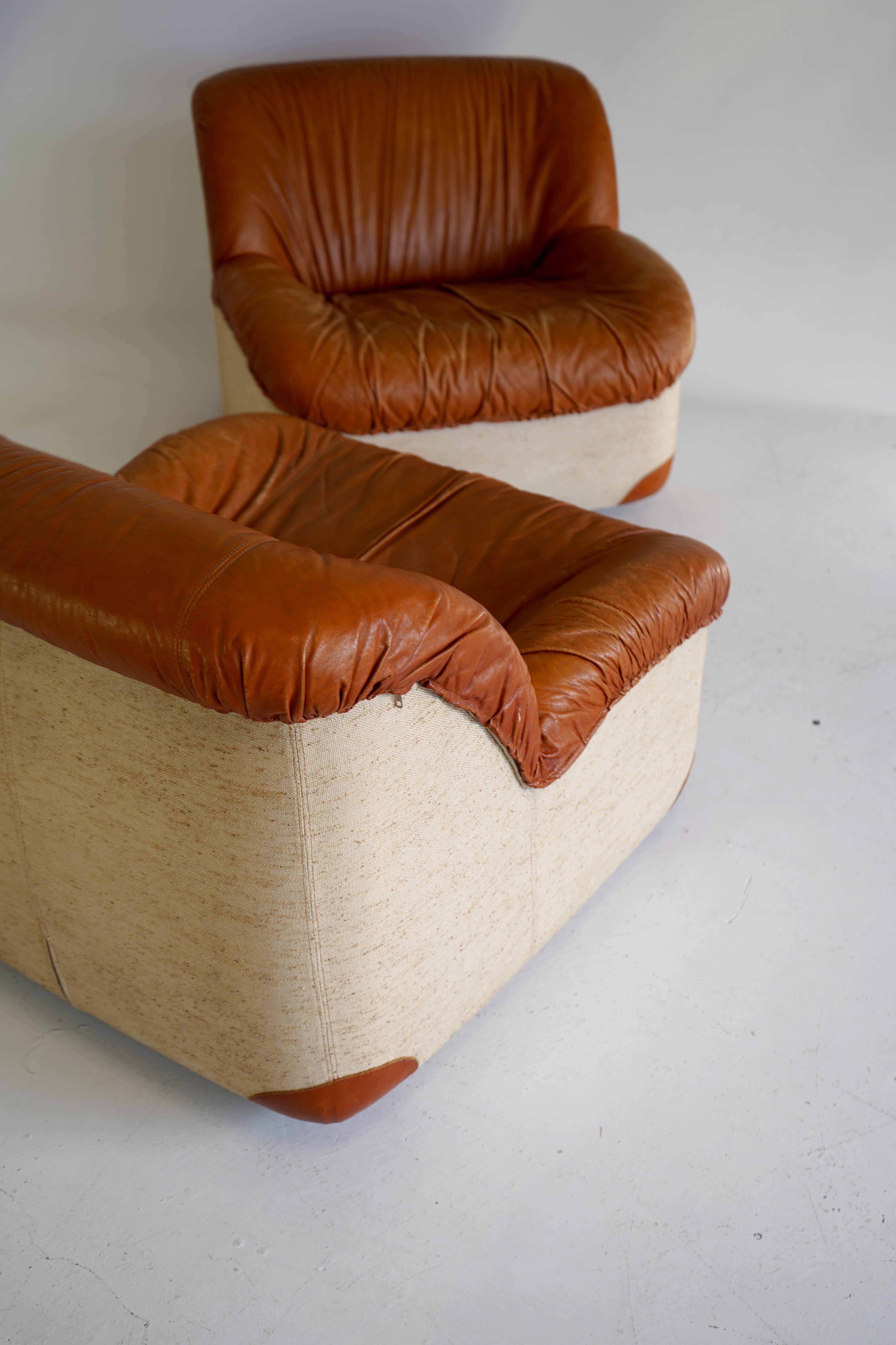Designed for Italian manufacturer Swan in the 1970s, these modern chairs feature 2 quintessential materials of the time: cognac leather and natural woven canvas. Beautiful, soft curves round out the design. Beautiful patina with no tears or major