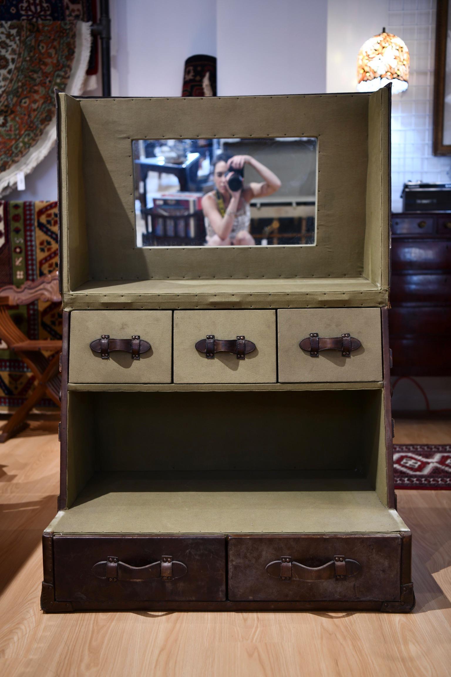 Leather and cowhide veneered trunk, transformed into desk or vanity. When opened, the piece reveals mirror and pull-out drawers. Dimensions: 35.5