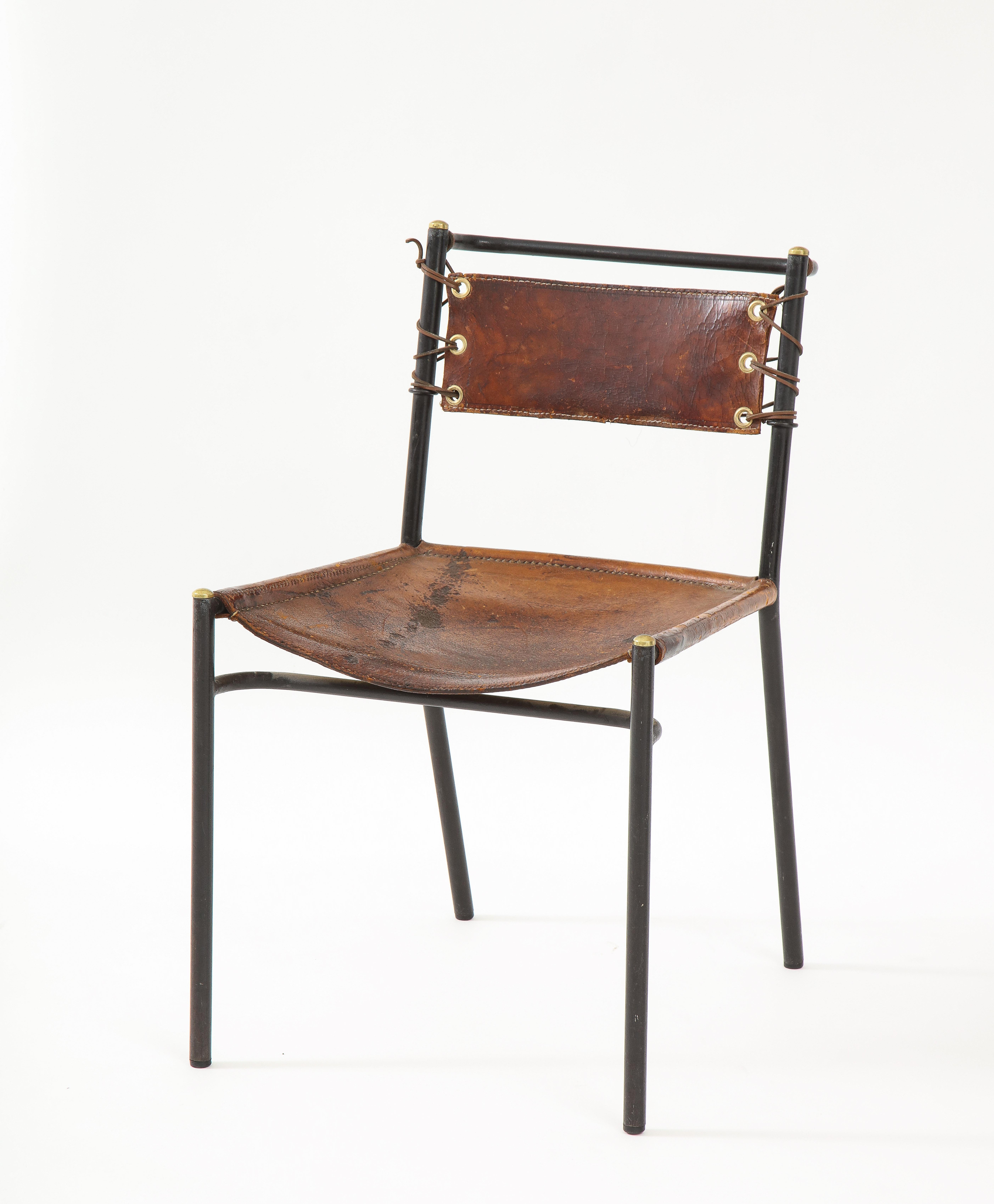 Stuhl aus Leder und Metall im Stil von Jacques Adnet, Frankreich, ca. 1950er Jahre. 

Das schlichte, aber raffinierte Design besteht aus einem sauberen Metallrohrrahmen, einem Ledersitz und einer handgeknüpften Lederrückenlehne. 

 