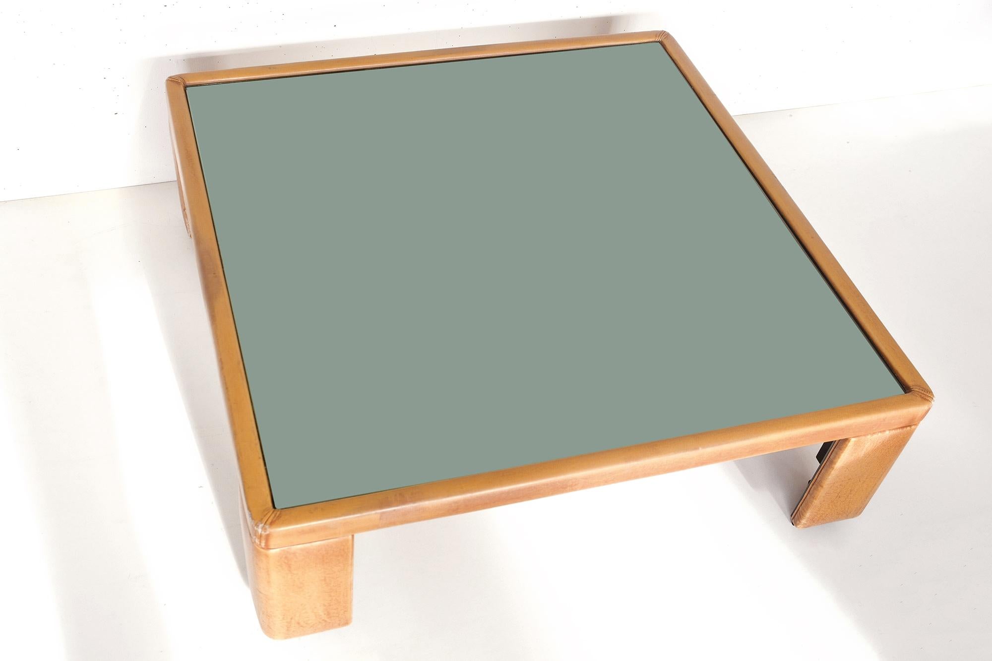 Beautiful coffee table in brown leather with a mirrored glass table top. Designed by Luigi Massoni for Poltrona Frau in the 1970’s. 
Original tag.