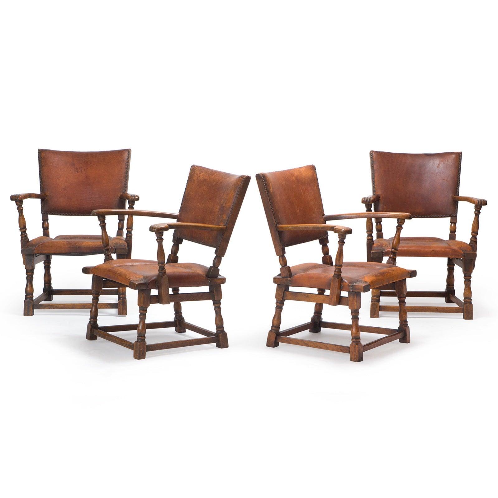 A rare leather and oak armchair with block turned legs and arms.