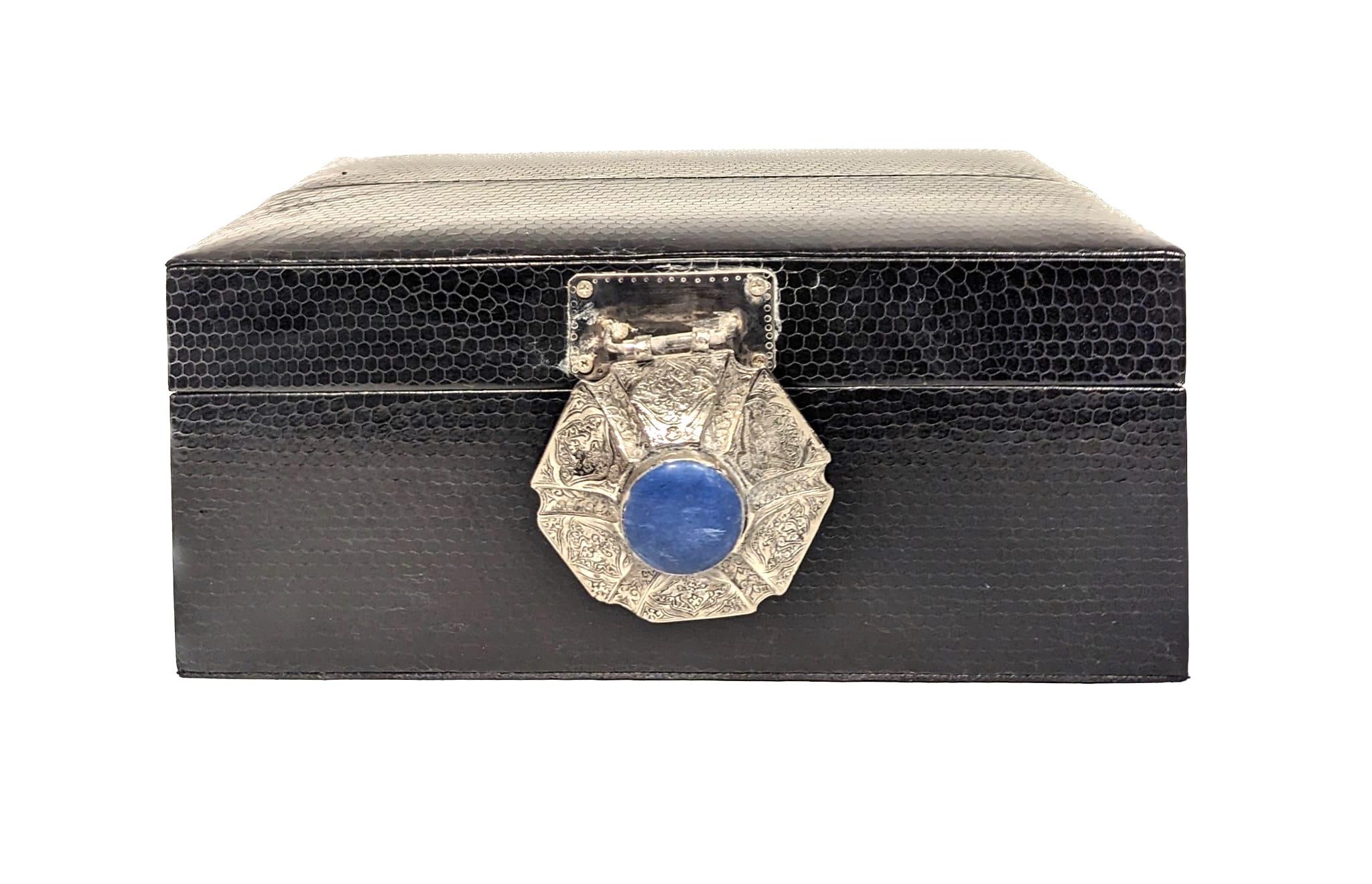 Diseñada en exclusiva por Urban Art, se ofrece una caja decorativa compuesta por un exterior de pitón negro y adornada con herrajes de plata de ley y un colgante afgano de plata y lapislázuli. 

La caja está forrada de ante negro y mide 9,875