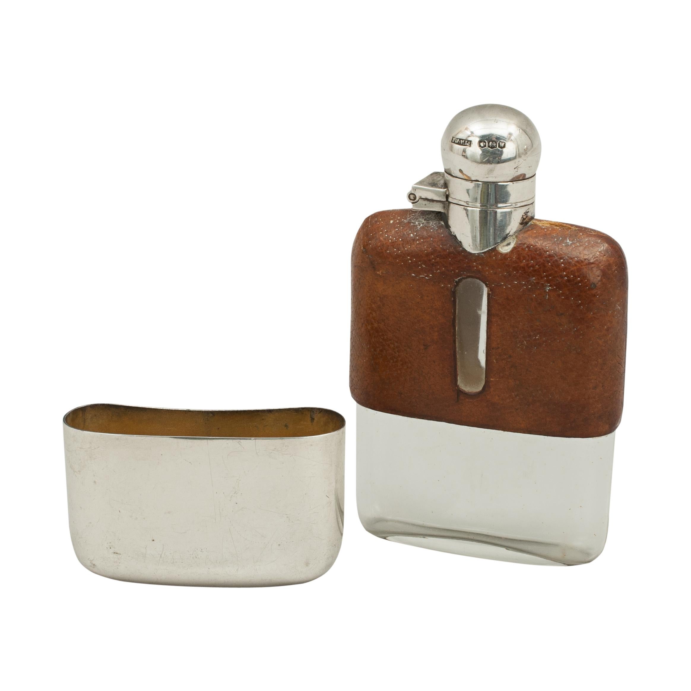 Leather and silver hip flask.
A very nice silver spirit hip flask with the top half covered in leather with level viewing windows cut into both sides. The flask with hinged lid with screw bayonet fitting, bottom with a removable silver drinking