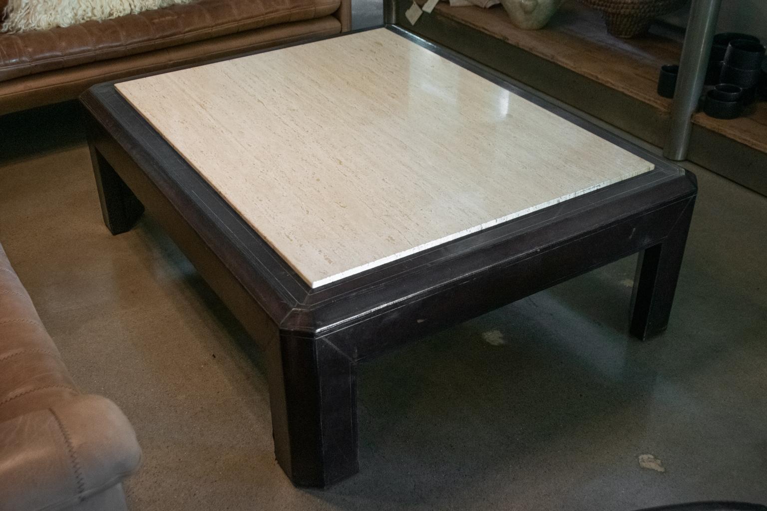 Vintage cocktail table with super 1980s Ralph Lauren styling. Heavy wood frame is wrapped in rich brown leather. Subtle embossed detail in leather. Inset travertine top.